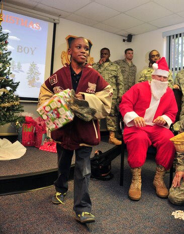 C.J. Pinckney takes his gift from the tree after his ticket number was called during a base tour Dec. 2, 2010, at Joint Base Charleston-Air Base, S.C. C.J. and fellow students from Memminger Elementary School met up at the Airman Leadership School for a picnic and holiday gift raffle following tour stops at the Air Park, 628th Security Forces Squadron military working dog kennels and the base fire department. Waiting for their ticket to be called, approximately 40 students all piled into the room at ALS and each received a gift. (U.S. Air Force photo/Staff Sgt. Daniel Bowles)