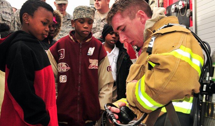 Lorenzo Simmons, left, and C.J. Pinckney listen in and learn about fire safety from Senior Airman Samuel Siewert during a base tour Dec. 2, 2010, on Joint Base Charleston-Air Base, S.C. At the fire house, children toured the fire engines and main building as fire fighters familiarized the students with equipment and practices used during emergency response. Lorenzo and C.J. were joined by third-grade classmates from Memminger Elementary School as well as students enrolled in the base's Airman Leadership School. Airman Siewert is a fire protection journeyman with the 628th Civil Engineer Squadron. (U.S. Air Force photo/Staff Sgt. Daniel Bowles)