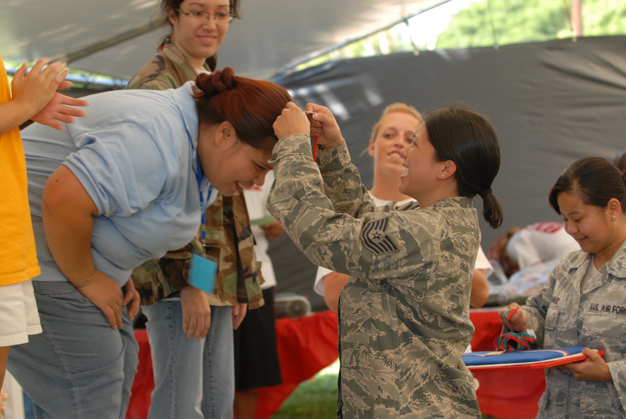 Tech. Sgt. Calantha Pickel, a Pacific Command Joint Intelligence Operations Center intelligence analyst, awards a medal to a participant of Special Olympics at Joint Base Pearl Harbor-Hickam, Hawaii, Dec. 4, 2010. (U.S. Air Force photo/Staff Sgt. Carolyn Viss)