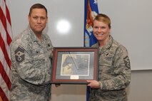 MINOT AIR FORCE BASE, N.D. -- Master Sgt. Jennifer Shelley, 5th Communications Squadron first sergeant, receives a plaque for successfully completing her first sergeant training during the first sergeant induction ceremony here Dec. 3. First sergeants work with fellow senior noncommissioned officers and supervisory personnel to ensure discipline is equitably maintained, and the health, esprit de corps, discipline, mentoring and welfare of the enlisted force are met. (U.S. Air Force photo/Airman 1st Class Aaron-Forrest Wainwright)