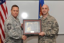 MINOT AIR FORCE BASE, N.D. -- Master Sgt. Patrick Lund, 5th Medical Group first sergeant, receives a plaque for successfully completing his first sergeant training during the first sergeant induction ceremony here Dec. 3. First sergeants work with fellow senior noncommissioned officers and supervisory personnel to ensure discipline is equitably maintained, and the health, esprit de corps, discipline, mentoring and welfare of the enlisted force are met. (U.S. Air Force photo/Airman 1st Class Aaron-Forrest Wainwright)