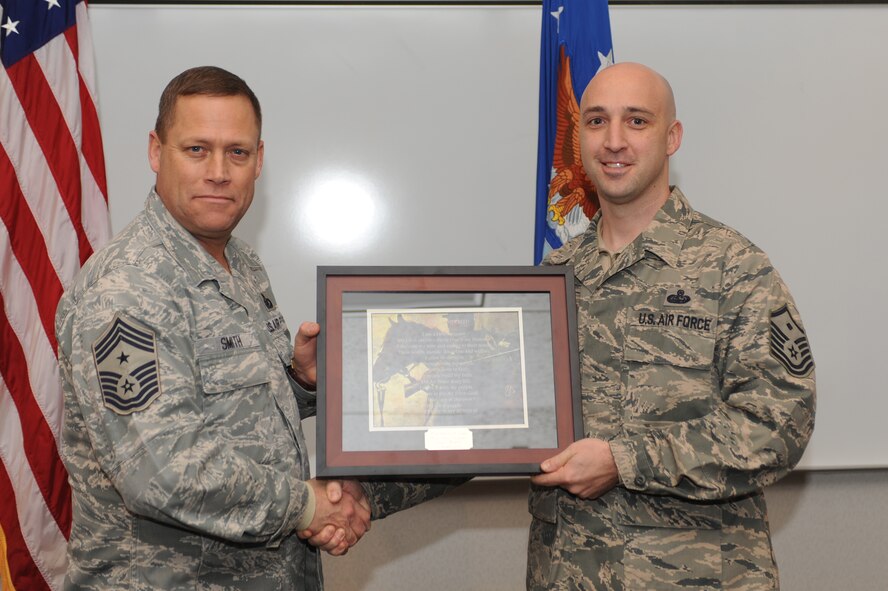 MINOT AIR FORCE BASE, N.D. -- Master Sgt. Patrick Lund, 5th Medical Group first sergeant, receives a plaque for successfully completing his first sergeant training during the first sergeant induction ceremony here Dec. 3. First sergeants work with fellow senior noncommissioned officers and supervisory personnel to ensure discipline is equitably maintained, and the health, esprit de corps, discipline, mentoring and welfare of the enlisted force are met. (U.S. Air Force photo/Airman 1st Class Aaron-Forrest Wainwright)