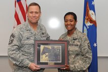 MINOT AIR FORCE BASE, N.D. -- Master Sgt. Temikia Clinkscales, 91st Missile Maintenance Squadron first sergeant, receives a plaque for successfully completing her first sergeant training during the first sergeant induction ceremony here Dec. 3. First sergeants work with fellow senior noncommissioned officers and supervisory personnel to ensure discipline is equitably maintained, and the health, esprit de corps, discipline, mentoring and welfare of the enlisted force are met. (U.S. Air Force photo/Airman 1st Class Aaron-Forrest Wainwright)
