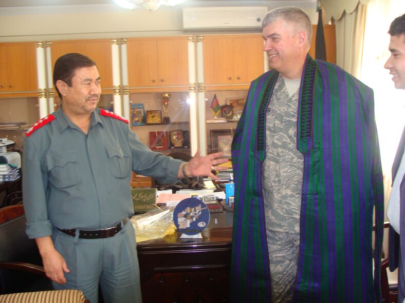 Lt Gen Muhammad Haider Basir (right), head of the Interior Ministry Logistics Department presents Col. Paul Cummings with a coat similar to the one frequently worn by Afghan President Hamid Karzai in August 2010.  (Submitted- National Guard Photo)