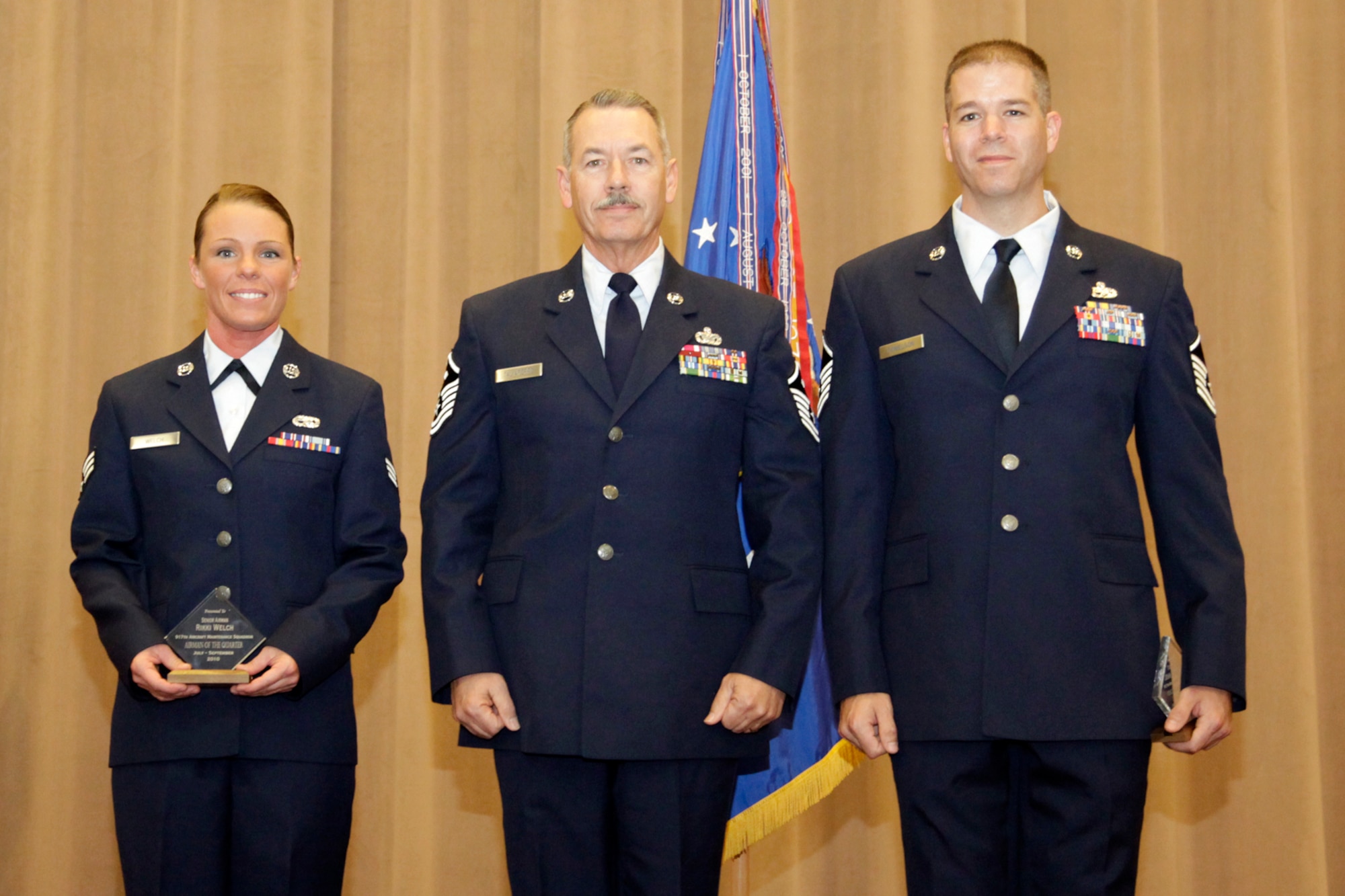 Master Sgt. James Taliaferro, a First Sergeant’s Association representative, poses between the 917th Wing Airman and Non-Commissioned Officer of the Quarter winners for the Third Quarter of 2010, during award ceremonies at the 917th Wing Commander’s Call in Hoban Hall at Barksdale Air Force Base, La., Dec. 5, 2010. Sergeant Taliaferro presented the “Diamond Sharp Award” to Senior Airman Rikki Welch, armament systems mechanic, and Master Sgt. John Donelson, electronic warfare systems mechanic, who are both assigned to the 917th Maintenance Squadron.  (U.S. Air Force photo /Staff Sgt. Travis Robertson)