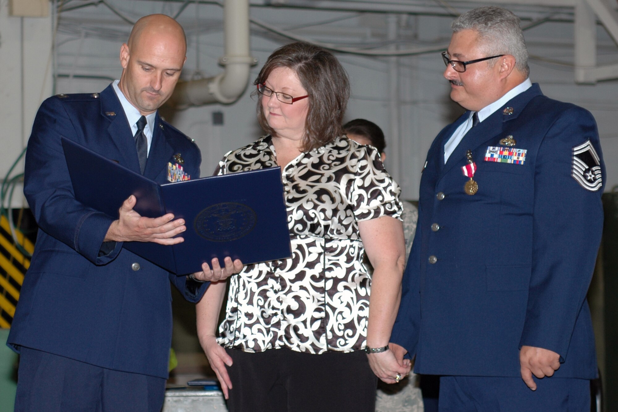 Capt. Brian Plauche, maintenance officer, 917th Maintenance Group, presents Suzanne Delgado the “Spouses Certificate of Appreciation” upon the retirement of her husband, Senior Master Sgt. Ruben Delgado, aircraft fabrication superintendent for the 917th Maintenance Squadron at Barksdale Air Force Base, La., Dec. 4, 2010. Sergeant Delgado retired from the 917th Wing after 27 years of service. (U.S. Air Force Photo/Master Sgt. Mary Hinson)