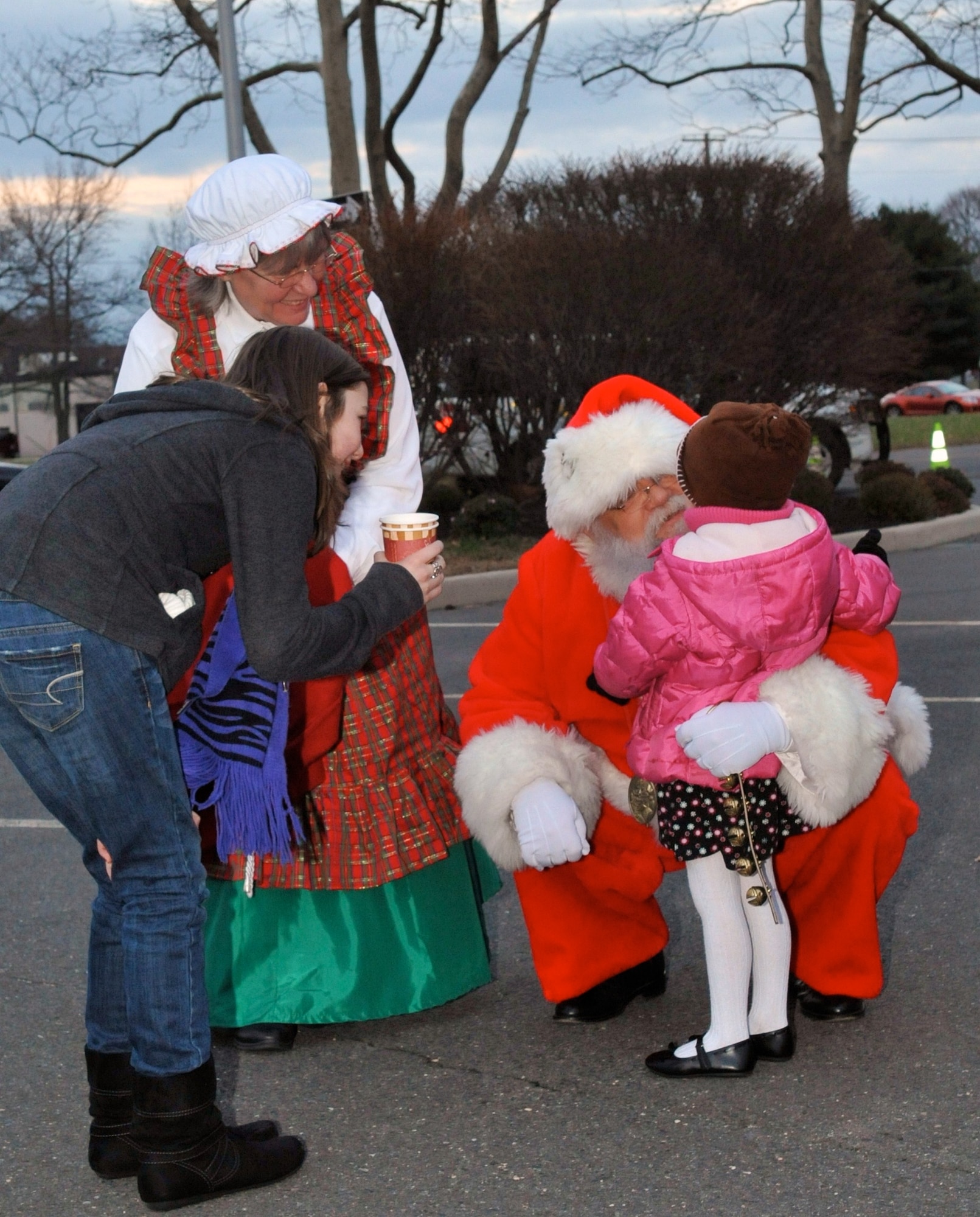 Emma Poth, daughter of Robin and Col. Joe Poth, Joint Base McGuire-Dix-Lakehurst deputy commander, receives a hug from Santa as she explains her wish list to him and Mrs. Claus Dec. 3 at the McGuire/Dix tree lighting ceremony. This holiday event, filled with cookies and hot chocolate, marked the start of the holiday season for joint base community members. The ceremony featured singing from Brownie Troop 22045, who placed second in the holiday card contest. (U.S. Air Force photo/ Wayne Russell)   