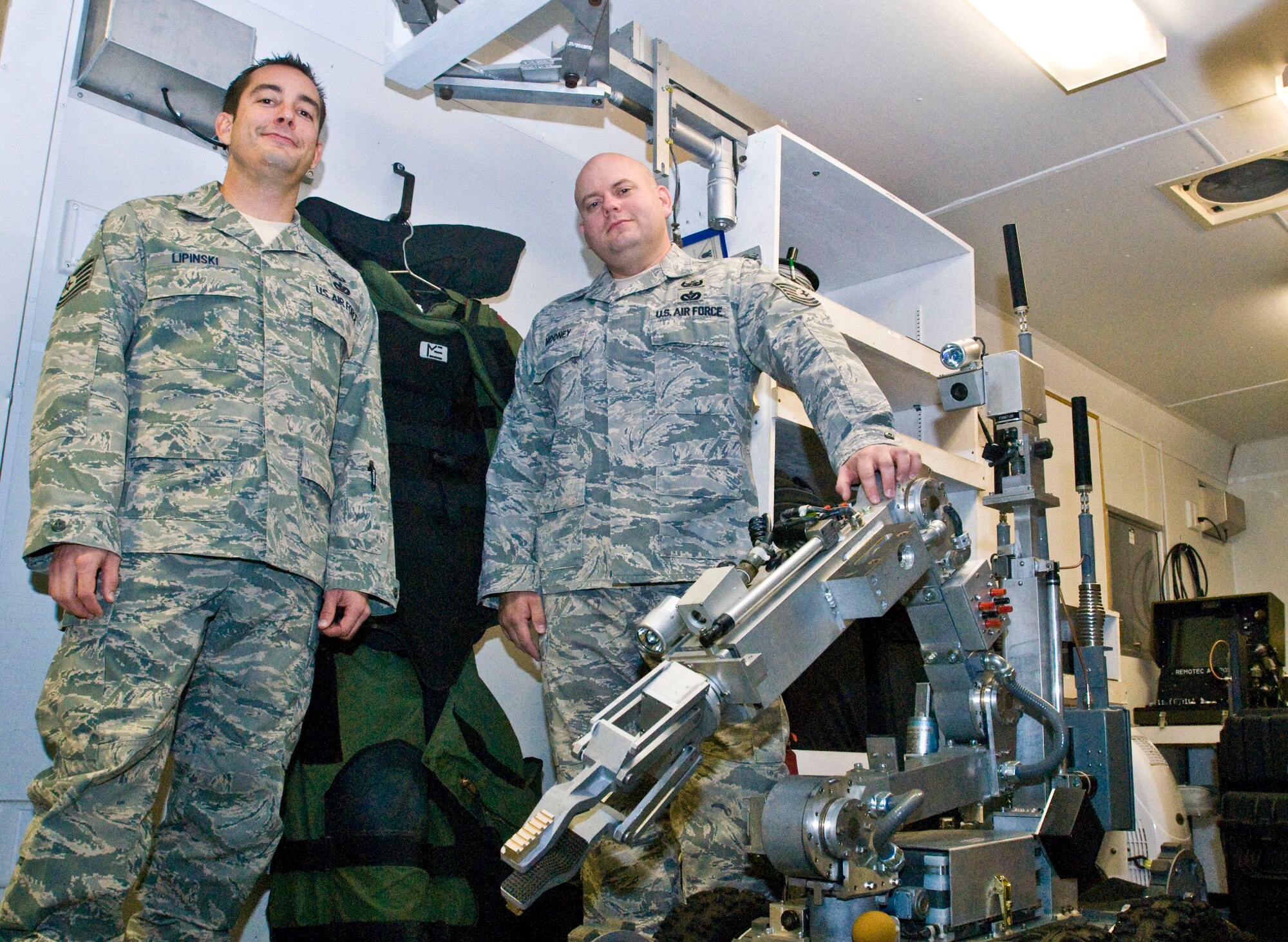 Tech. Sgts. Lawrence Lipinski (left) and Heath Mooney, both 19th Civil Engineer Squadron explosives ordnance disposal technicians, stand among the tools used on EOD missions Dec. 6 at Little Rock Air Force Base, Ark. The two NCOs each received their second Bronze Star medal for meritorious service during deployments to Iraq and Afghanistan. (U.S. Air Force photo by Staff Sgt. Nestor Cruz)