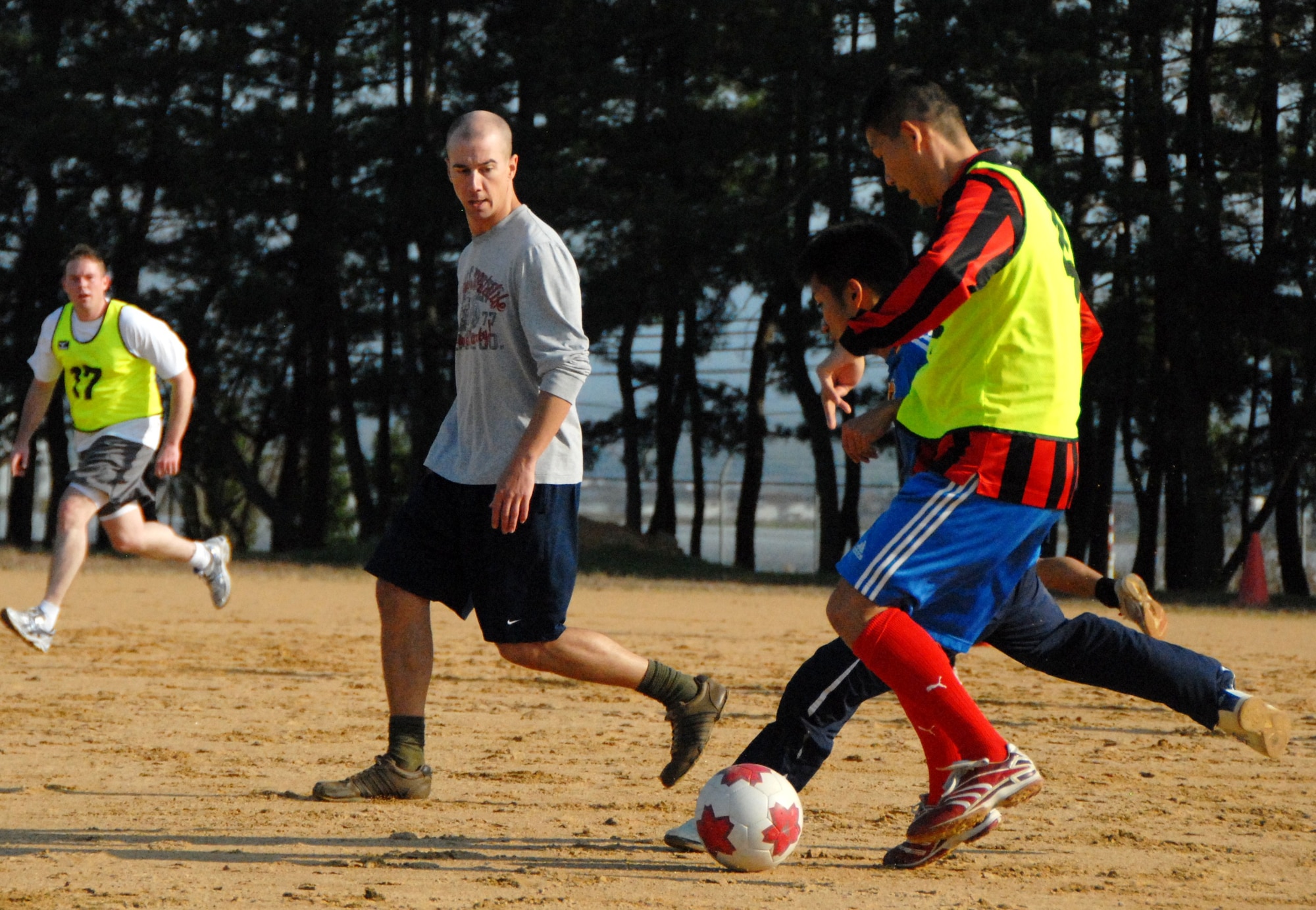U.S. Air Force Staff Sgt. Brandon Pfleegor, 644 Combat Communications Squadron, passes the ball to a Japan Air Self-Defense Force member during a soccer scrimmage at Komatsu Japan Air Self-Defense Force base, Dec. 5, 2010. More than 20 JASDF and U.S. Air Force members took a break from the flightline in favor of the soccer field during operations at Keen Sword 2011. (U.S. Air Force photo by 1st Lt. Cammie Quinn/ Released) 