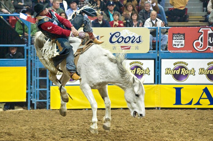LAS VEGAS-- Clint Cannon, from Waller, Texas, rides Peaches and Cream to an 86.5 second place finish during the bareback competition in the fourth round of the National Finals Rodeo at the Thomas and Mack Center Dec. 5. The NFR paid tribute to the men and women of the armed forces for their service to our country. (U.S. Air Force photo by Lawrence Crespo/Released) 