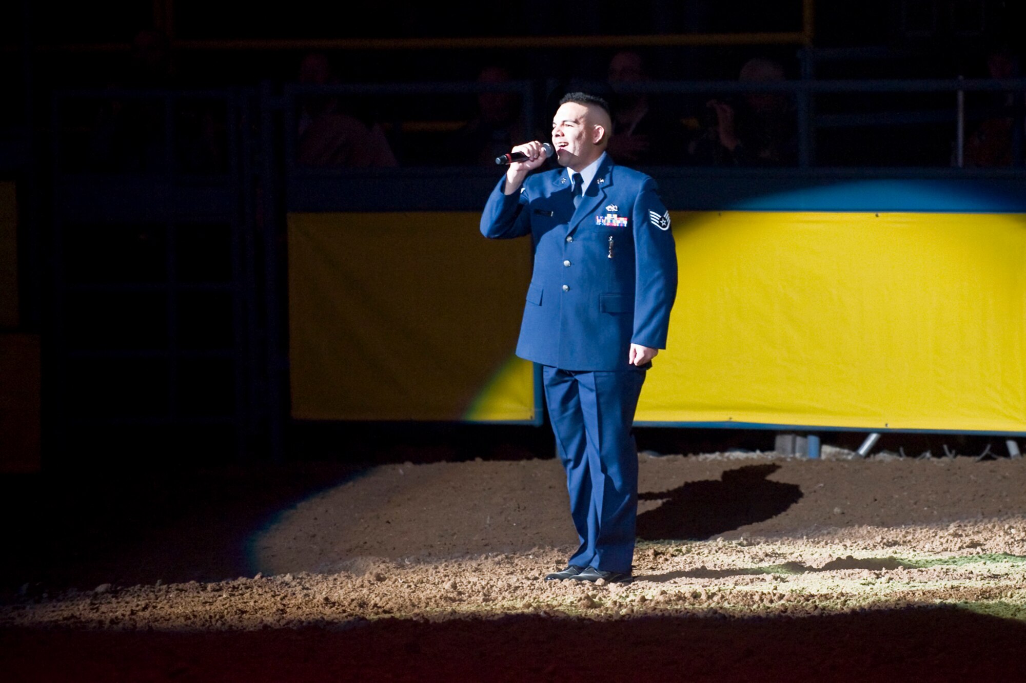 LAS VEGAS - Staff Sgt. Brian Pop, a weapons load crew chief assigned to the 757th Aircraft Maintenance Squadron at Nellis Air Force Base, Nev., sings the national anthem during the opening ceremony of the National Finals Rodeo at the Thomas and Mack Center Dec. 5. The NFR paid tribute to the men and women of the armed forces for their service to our country. (U.S. Air Force photo by Lawrence Crespo/Released) 