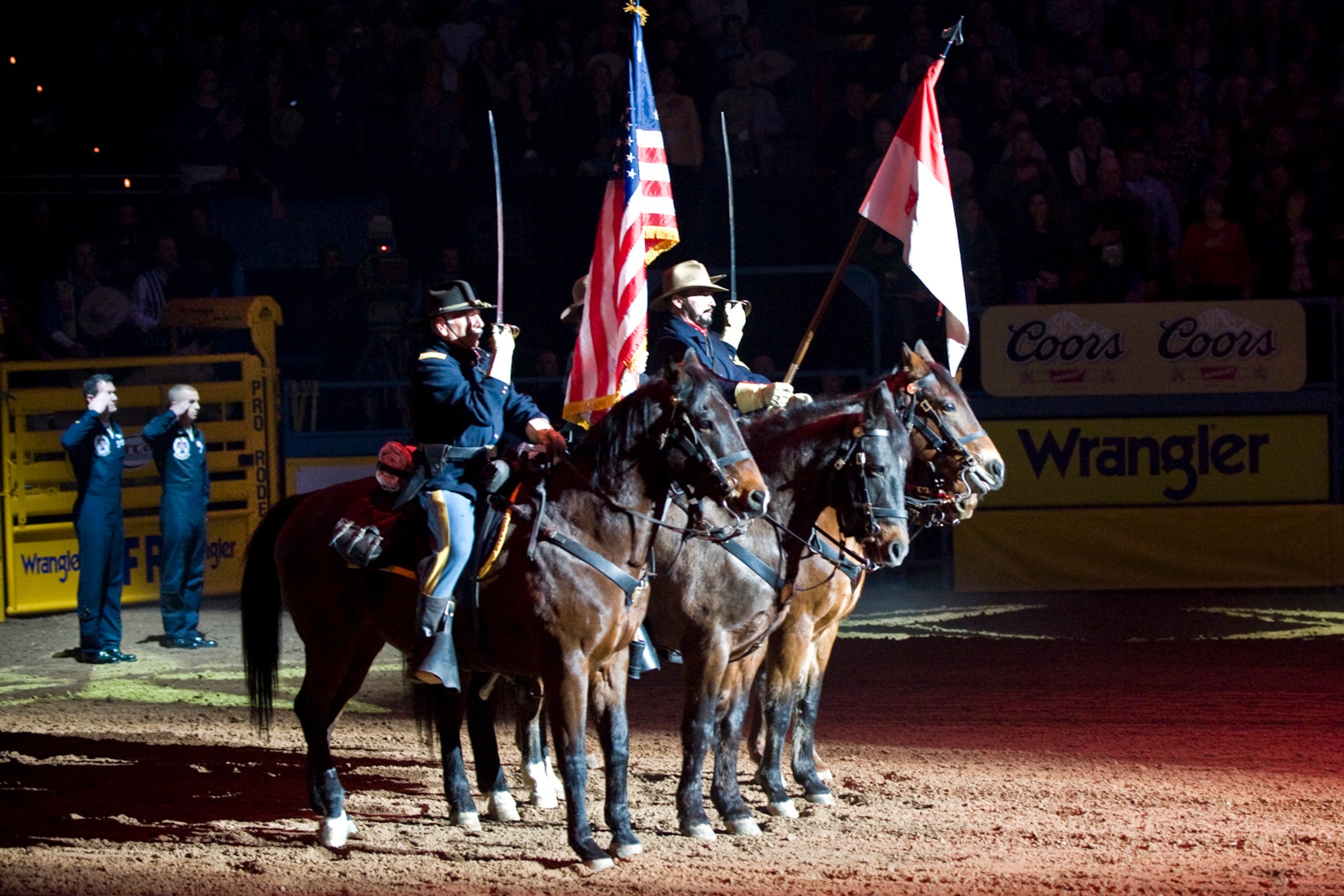LAS VEGAS -- Members from B Troop, 4th U.S. Cavalry (Memorial), Fort Huachuca, Ariz., and the U.S. Air Force Air Demonstration Squadron "Thunderbirds",  Nellis Air Force Base, Nev., render a salute during the singing of the national anthem at opening ceremony of the National Finals Rodeo at the Thomas and Mack Center Dec. 5. The NFR paid tribute to the men and women of the armed forces for their service to our country. (U.S. Air Force photo by Lawrence Crespo/Released) 