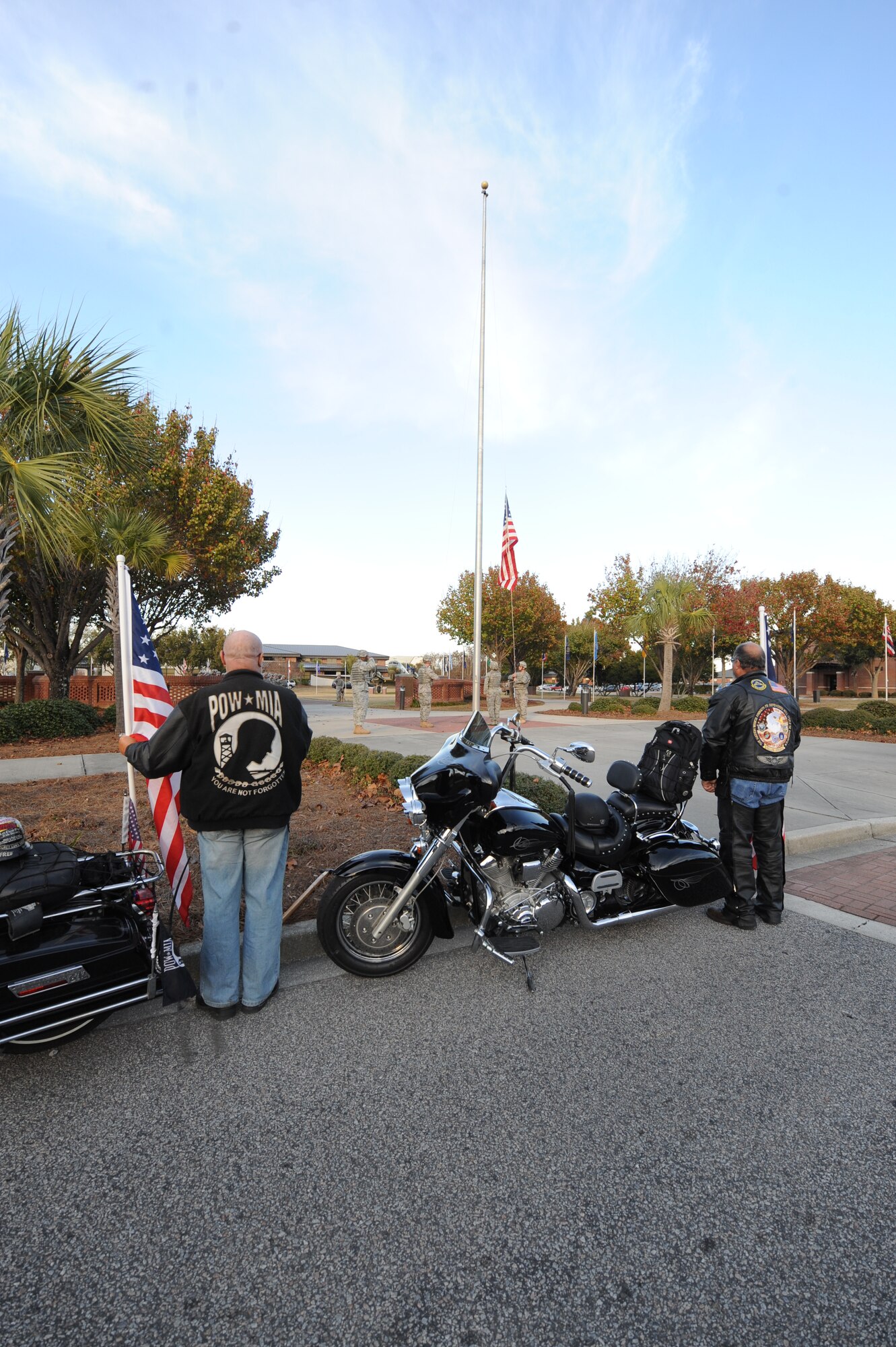 Patriot Guard Riders stand at attention next to their motorcycles while members from the 628th Security Forces Squadron lower the flag during a retreat ceremony at Joint Base Charleston-Air Base, S.C., Dec. 3, 2010. The retreat ceremony is coordinated with the playing of the national anthem and the lowering of the flag so that the two are completed at the same time. The Patriot Guard Riders is a diverse group of motorcycle riders across the nation who pay respect for those who risk their lives for America's freedom and security. (U.S. Air Force photo/James M. Bowman)