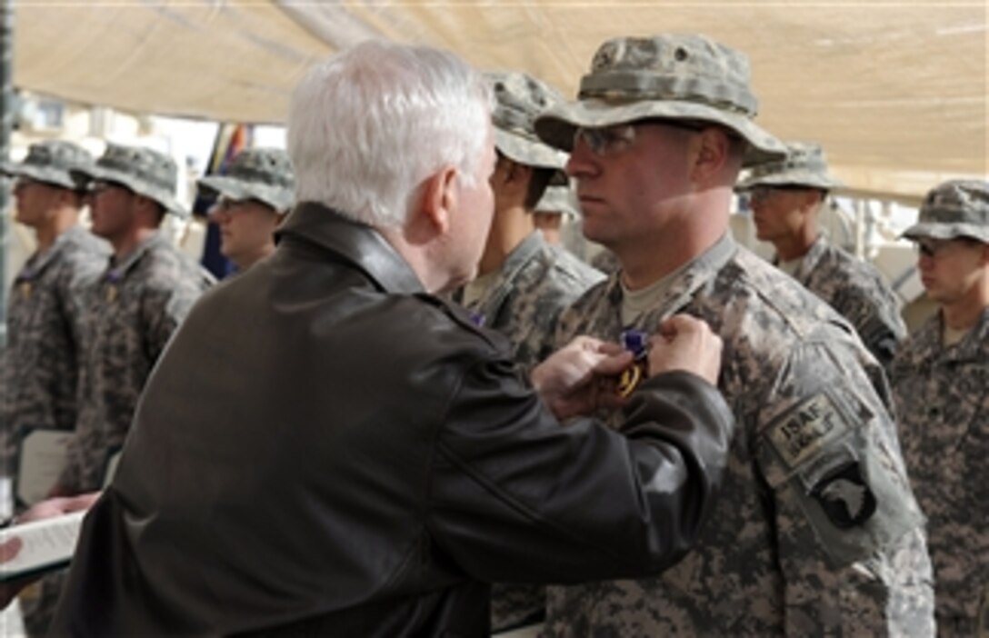 Secretary of Defense Robert M. Gates pins the Purple Heart Medal on Pfc. Brandon J. Davis, 2nd Battalion 502nd Infantry Regiment, 101st Airborne Division, at Forward Operating Base Howz-E-Madad, Afghanistan, on Dec. 8, 2010.  Gates pinned Purple Hearts, Bronze Stars with Valor and Army Commendation Medals with Valor on deployed Screaming Eagle soldiers from the 101st Airborne.  