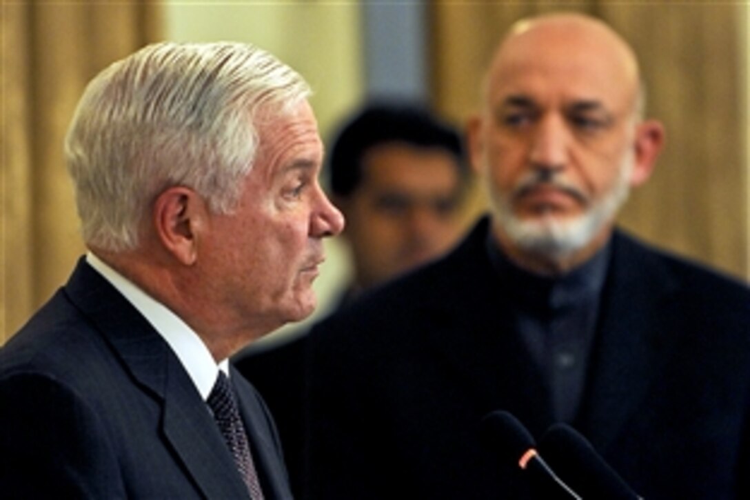 U.S. Defense Secretary Robert M. Gates answers a question from the press while Afghan President Hamid Karzai looks on at the Presidential Palace in Kabul, Afghanistan, Dec. 8, 2010.