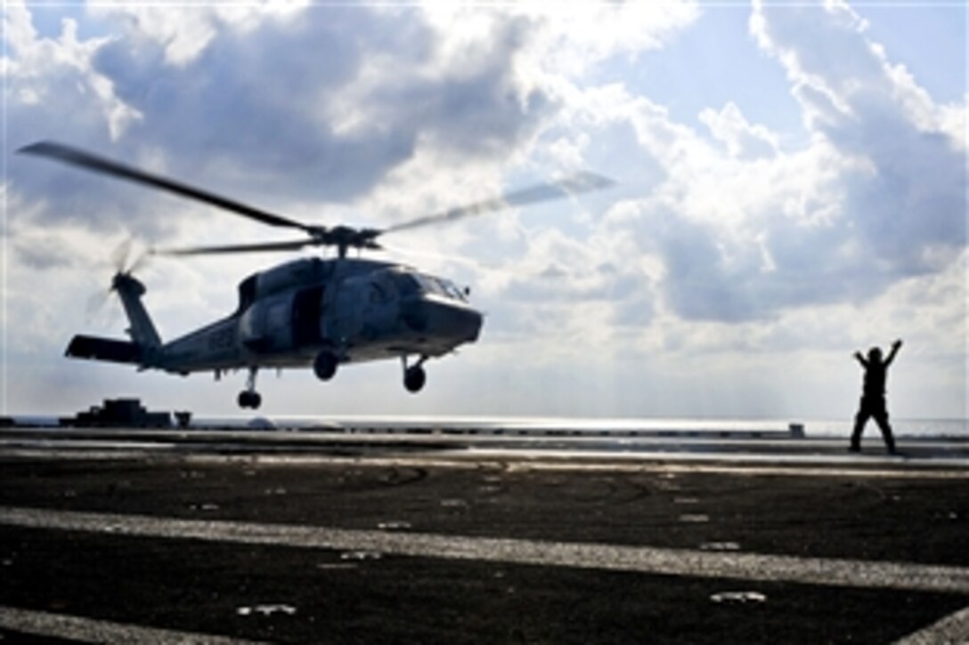 An SH-60S Seahawk helicopter carrying U.S. Navy Vice Adm. Scott Van Buskirk, commander of U.S. 7th Fleet, and Kenichi Kuramoto, vice admiral of the Japan Maritime Self-Defense Force, approaches the aircraft carrier USS George Washington in the East China Sea, Dec. 6, 2010. The George Washington was participating in Keen Sword 2010, a U.S.-Japan joint naval exercise to improve interoperability and enhance force readiness.