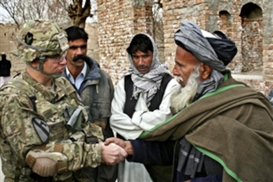 U.S Army Capt. Joshua MacLean and Abdul Rahim Mazai, malik of the town of Bajawri, shake hands outside a village mosque in Afghanistan's Parwan province, Dec. 6, 2010. MacLean is an information officer assigned to the 1st Squadron, 113th Cavalry Regiment.