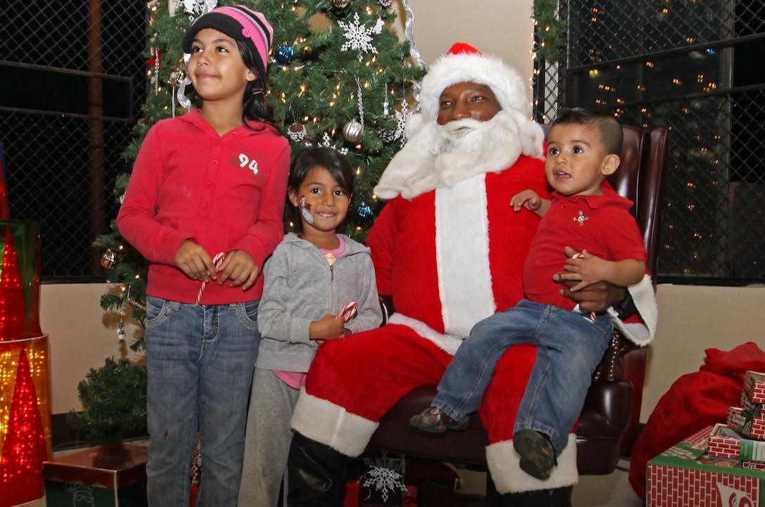 (From left to right) Alyssa, Tatiana, and Ruben Villarreal sit with Santa Claus and tell him their Christmas wishes during Camp Pendleton’s South Mesa Community Center Winter Festival, Dec. 8. Service members and their families were provided with free pony rides, face paintings, moon bounces, paintball gun shooting area, and character drawing.