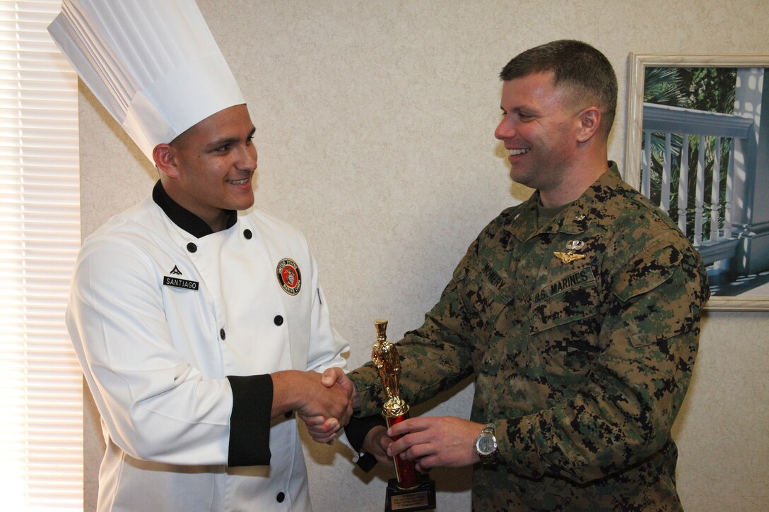 Lt. Col. Samuel P. Mowery, right, presents Lance Cpl. Jose A. Santiago the first-place trophy for Cherry Point’s first chef of the quarter competition of the fiscal year at the Cherry Point Mess Hall Dec. 9. “The food was excellent, and both competitors did a great job,” said Mowery, the commanding officer of Headquarters and Headquarters Squadron here. Santiago is a food service specialist with Marine Wing Support Squadron 274.