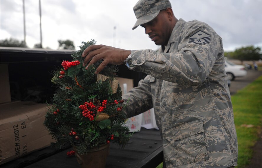 Master Sgt. Wesley Matthews, 15th Medical Group first sergeant prepares to deliver miniature Christmas trees to Airmen in the dorms  as part of the annual Cookie Caper event Dec. 9 at Joint Base Pearl Harbor-Hickam, Hawaii. Sergeant Matthews, as well as 60 volunteers donated their time to raising Airmen's spirits for the holiday season. (U.S. Air Force Photo/Airman 1st Class Lauren Main)