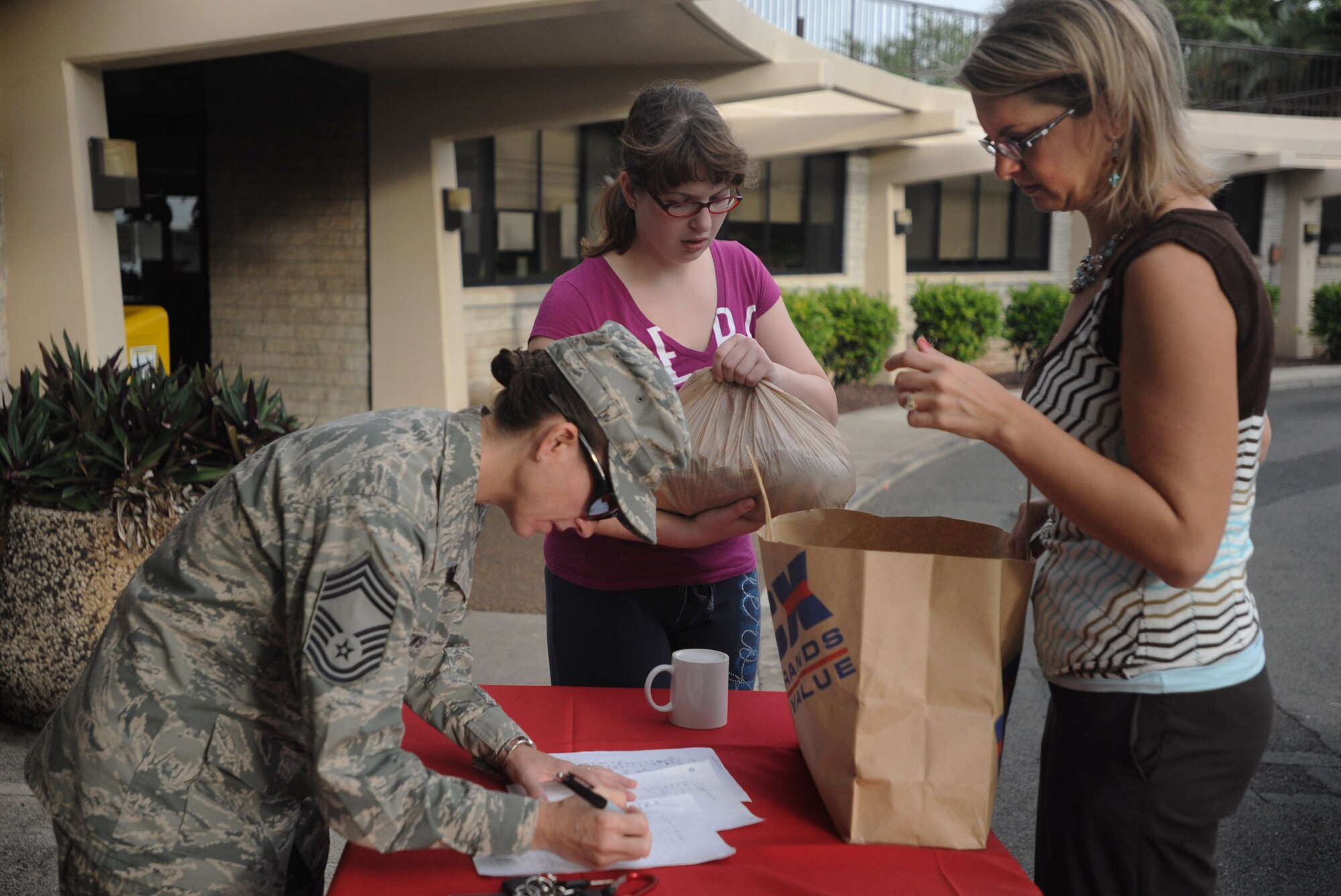 Tara Stewart (right)15th Operations Support Squadron unit program coordinator  drops off cookies that she made for Airmen and their families as part of the annual Cookie Caper event Dec. 9 at Joint Base Pearl Harbor-Hickam, Hawaii. More than 27,000 cookies were baked and donated to brighten the spirits of Airmen stationed here. (U.S. Air Force Photo/Airman 1st Class Lauren Main)