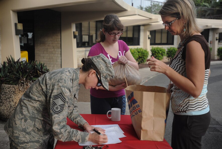 Tara Stewart (right)15th Operations Support Squadron unit program coordinator  drops off cookies that she made for Airmen and their families as part of the annual Cookie Caper event Dec. 9 at Joint Base Pearl Harbor-Hickam, Hawaii. More than 27,000 cookies were baked and donated to brighten the spirits of Airmen stationed here. (U.S. Air Force Photo/Airman 1st Class Lauren Main)
