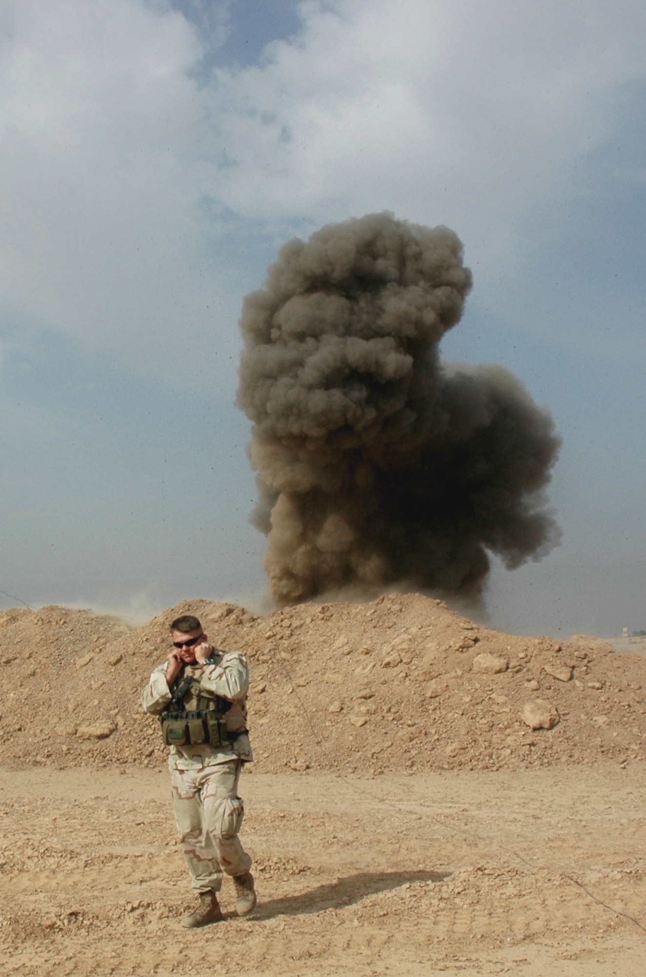 Master Sgt. John Beebe, an explosives ordnance disposal technician, performs a controlled detonation of an explosive device during his Iraq deployment, Oct. 19, 2006. Sergeant Beebe, a 20-year Marine Corps and Air Force veteran, is currently Kadena's 18th Civil Engineer Squadron EOD superintendent. (courtesy photo)