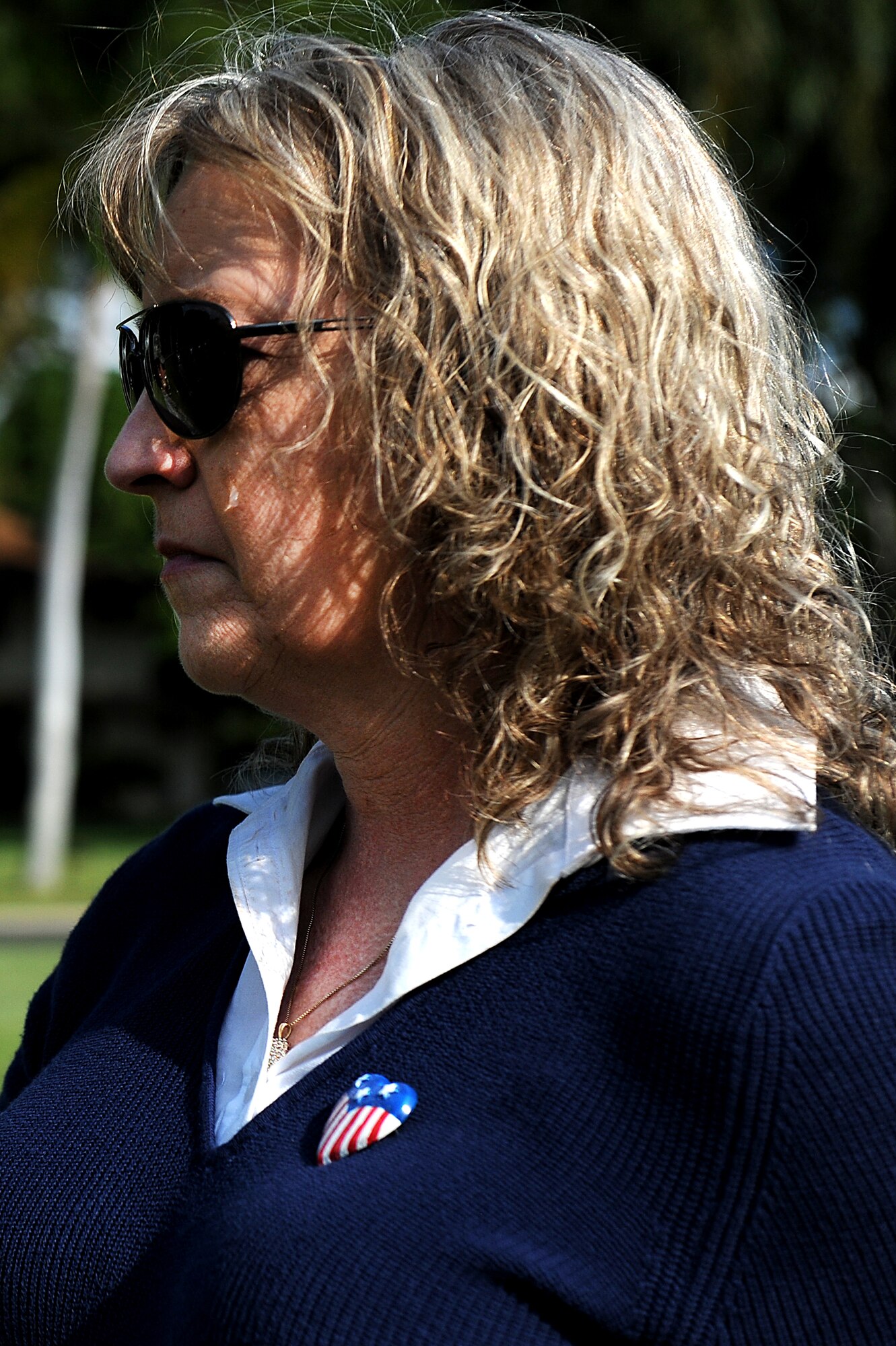 A tear rolls down Tina Marzan?s cheek after accepting the flag carried by the members of the 15th Medical Group during remembrance march of the attacks on Hickam Field and Pearl Harbor Dec. 7. Eight Medical group Airmen marched more than 69 accumulated miles in their combat boots and carrying a stretcher. Mrs. Marzan?shusband lost two grandparents during the attacks 69 years ago. (U.S. Air Force photo/Staff Sgt. Meares)