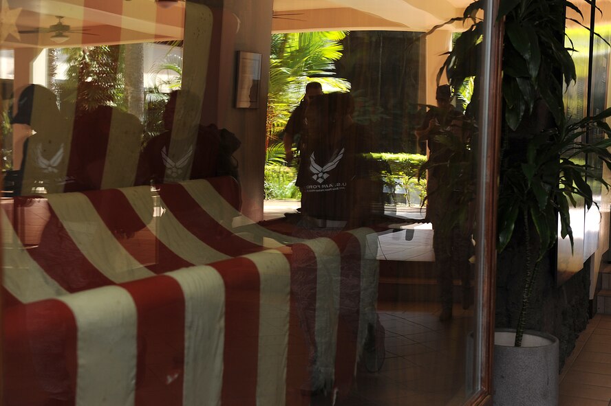 Member s of the 15th Medical Group carries a stretcher with a uniform of a World War II Army Air Corps medical corpsman march past the case housing the American Flag that flew on Dec. 7, 1941, located in the Pacific Air Forces Headquarters Courtyard of Heroes, during a more than 14-mile march Dec. 7. Eight Medical group Airmen marched more than 69 accumulated miles in their combat boots, carrying a stretcher and weighted backpacks to honor the pain and sacrifice Americans went through 69 years ago in Hawaii. Hickam and Pearl Harbor were simultaneously attacked at 7:55 a.m. (U.S. Air Force photo/Staff Sgt. Mike Meares)