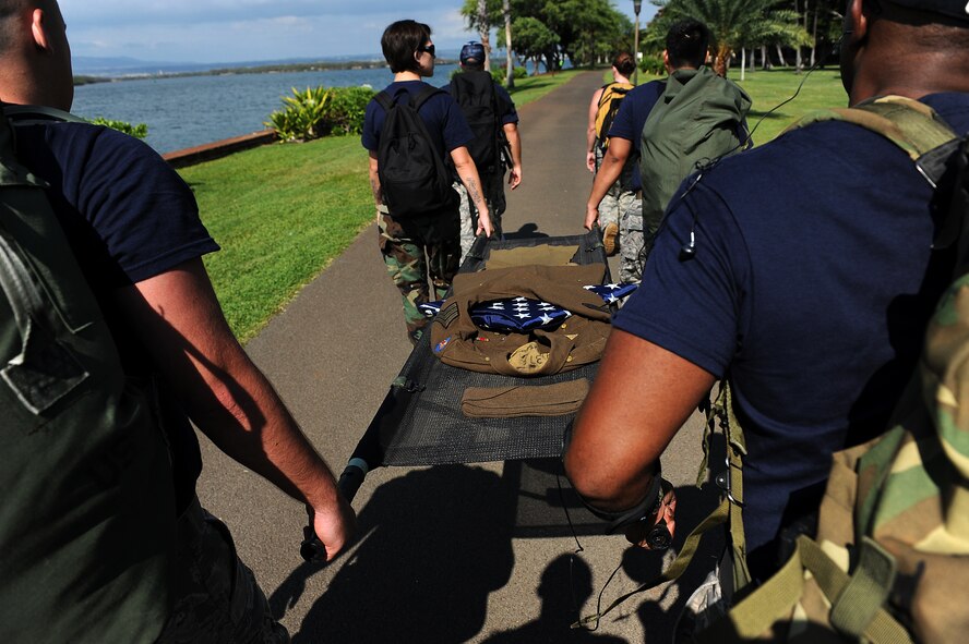 Member s of the 15th Medical Group carries a stretcher with a uniform of a World War II Army Air Corps medical corpsman along the banks of Pearl Harbor during a more than 14-mile march Dec. 7.   Eight Medical group Airmen marched more than 69 accumulated miles in their combat boots, carrying a stretcher and weighted backpacks to honor the pain and sacrifice Americans went through 69 years ago in Hawaii. Hickam and Pearl Harbor were simultaneously attacked at 7:55 a.m. (U.S. Air Force photo/Staff Sgt. Mike Meares)