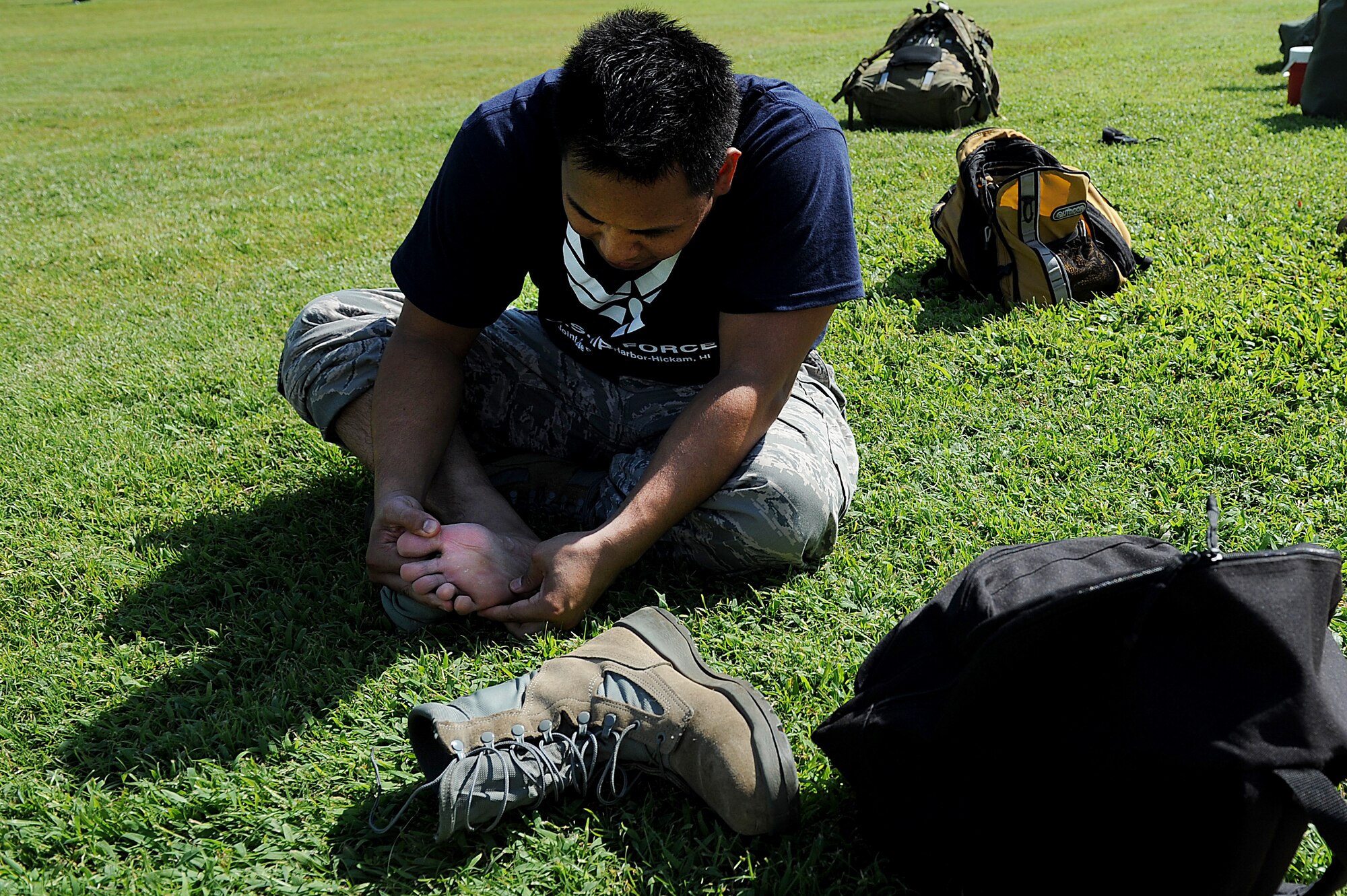 Tech. Sgt Calvin Montero, 15th Aeromedical Dental Squadron, checks for blisters during a more than 14-mile march Dec. 7. Eight Medical group Airmen marched more than 69 accumulated miles in their combat boots, carrying a stretcher and weighted backpacks to honor the pain and sacrifice Americans went through 69 years ago in Hawaii. (U.S. Air Force photo/Staff Sgt. Mike Meares)