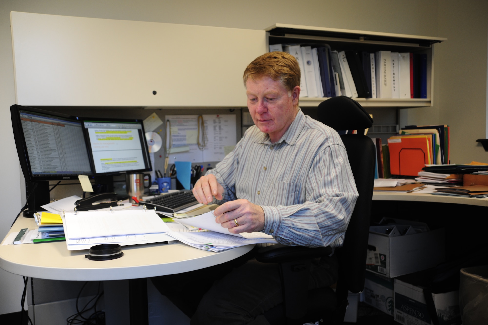 Ed McKenzie, 62nd Airlift Wing Civilian Personnel Office labor relations officer, organizes paper work Dec. 9 at McChord Field, Joint Base Lewis-McChord, Wash. The 62nd Force Support Squadron Civilian Personnel Office has won 2010 Air Mobility Command Civilian Personnel Program of the Year. (U.S. Air Force photo/Airman Leah Young)