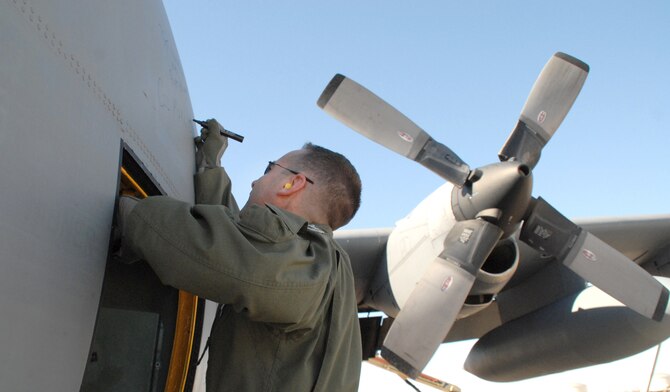 Col. Mark Czelusta signs his name on a C-130E Hercules after it completed its final flight Nov. 29, 2010, to Davis-Monthan Air Force Base's 309th Aerospace Maintenance and Regeneration Group in Arizona. It's Air Force tradition for the crew who flies an aircraft's final flight to sign the aircraft after landing. The C-130 was retired as part of an Air Force effort to modernize its C-130 fleet with C-130J and C-130H AMP aircraft. Colonel Czelusta is the 314th Airlift Wing commander and was the aircraft commander for the flight. (U.S. Air Force photo/Capt. Joe Knable)