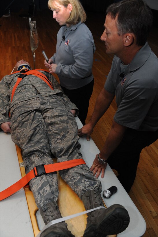 LANGLEY AIR FORCE BASE, Va. - Senior Airman Jason Haddock, (left), 71st Fighter Wing crew chief, plays the role of an accident victim while Kirsten Svela, (center), firefighter/paramedic, and Vince Easevoli, firefighter/paramedic, demonstrate the process a patient goes through while suffering from major injuries from a car accident Dec. 9. Ms. Svela and Mr. Easevoli is part of the Florida S.A.F.E. (Stay Alive From Education) Inc., an international nonprofit organization dedicated to making teens and military personnel aware of the consequences of driving under the influence, illegal drug use, non-compliance of seat belts, a and the trauma associated with these dangers.  (U.S. Air Force photo/Senior Airman Brian Ybarbo) (RELEASED)