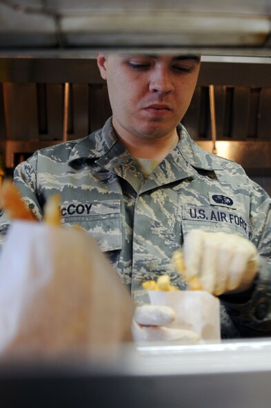 Senior Airman Barry McCoy, 2nd Force Support Squadron, food service specalist prepares fries to be served during lunch at the Flight Kitchen on Barksdale Air Force Base, La., Dec. 9. The Airmen of the 2 FSS provide key activities and programs to promote readiness, family well-being and quality of life to more than 57,000 military, civilians, retirees and family members of the Barksdale community. (U.S. Air Force photo/Senior Airman Brittany Y. Bateman)(RELEASED)