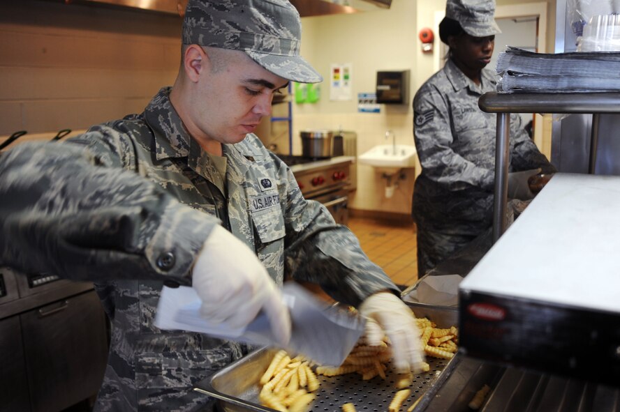 Senior Airman Barry McCoy, 2nd Force Support Squadron, food service specalist prepares fries to be served during lunch at the Flight Kitchen on Barksdale Air Force Base, La., Dec. 9. The Airmen of the 2 FSS provide key activities and programs to promote readiness, family well-being and quality of life to more than 57,000 military, civilians, retirees and family members of the Barksdale community. (U.S. Air Force photo/Senior Airman Brittany Y. Bateman)(RELEASED)