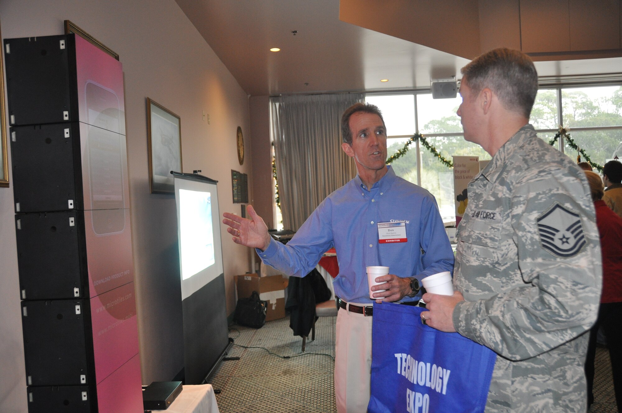 Master Sgt. Clint Rodgers, 325th Communication Squadron deputy element chief, looks along with Dan Smith, Christie Digital representative, at the exhibit of Christie Micro Tiles at the Technology Expo Dec. 8.  (U.S. Air Force photo/Senior Airman Veronica McMahon)