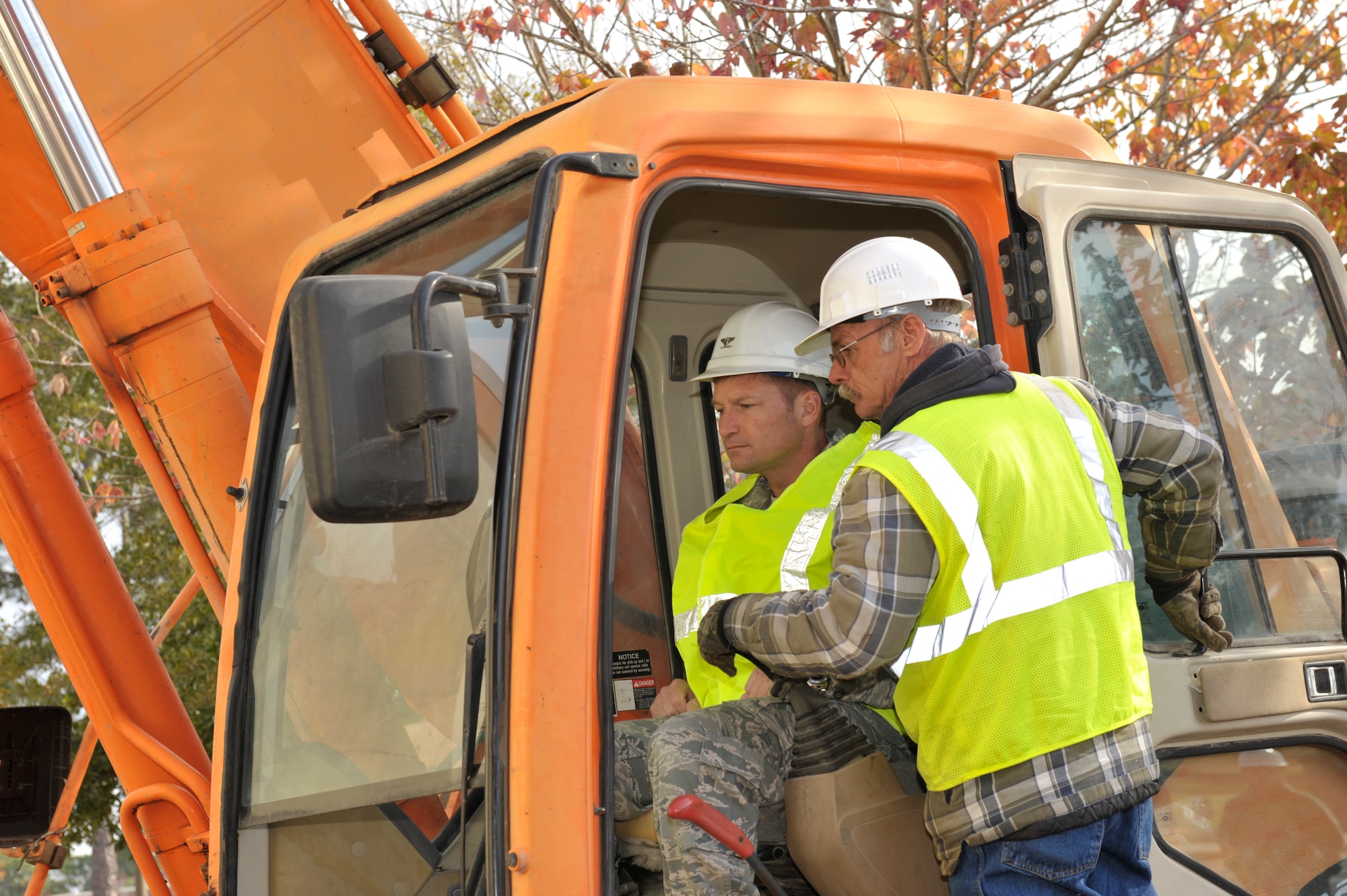 Col. Michael Fleck, 325th Mission Support Group commander, receives a quick
'how-to' before operating the excavator that will tear out the first chunk
of wall to begin the demolition of Tyndall's old fitness center building.
"This is a fun part of the progress," Colonel Fleck said. "Tearing down an
old facility that has served so many Airman for so many years." The 23,175
square foot building will undergo a five-week demolition process after
serving the base for 35 years. (U.S. Air Force photo by Jonathan Gibson)
