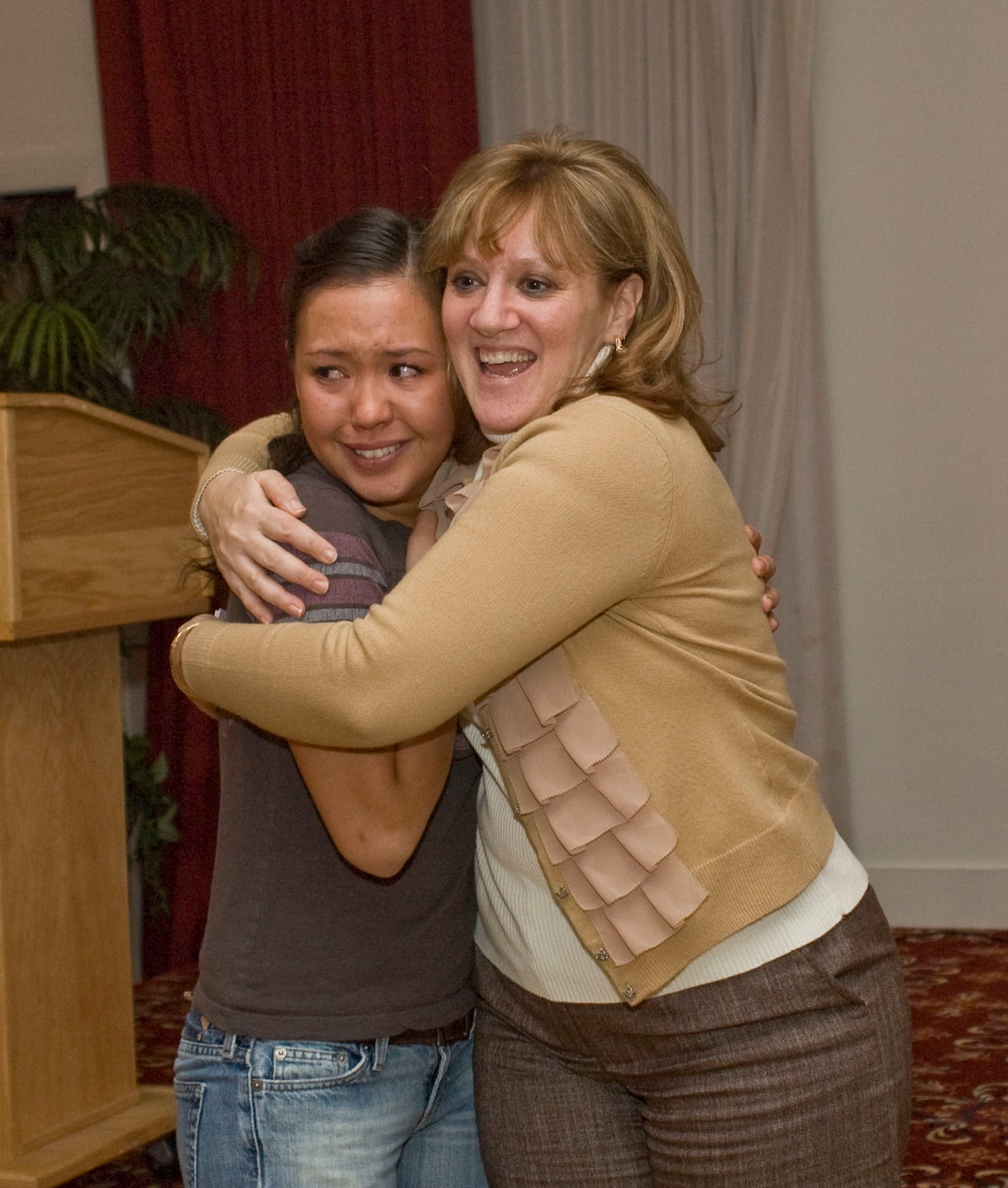 HANSCOM AIR FORCE BASE, Mass. – After drawing a name for a free plane ticket, Cynthia Nunes-Taijeron (right) gives winner Airman 1st Class Jennifer Grayson a hug during a reception at the Minuteman Club on Nov. 18. The Hanscom Senior NCO Association (Top 3) and the Hanscom First Sergeants Association sponsored a Fly an Airman Home for the Holidays program this year. (U.S. Air Force photo by Mark Herlihy)