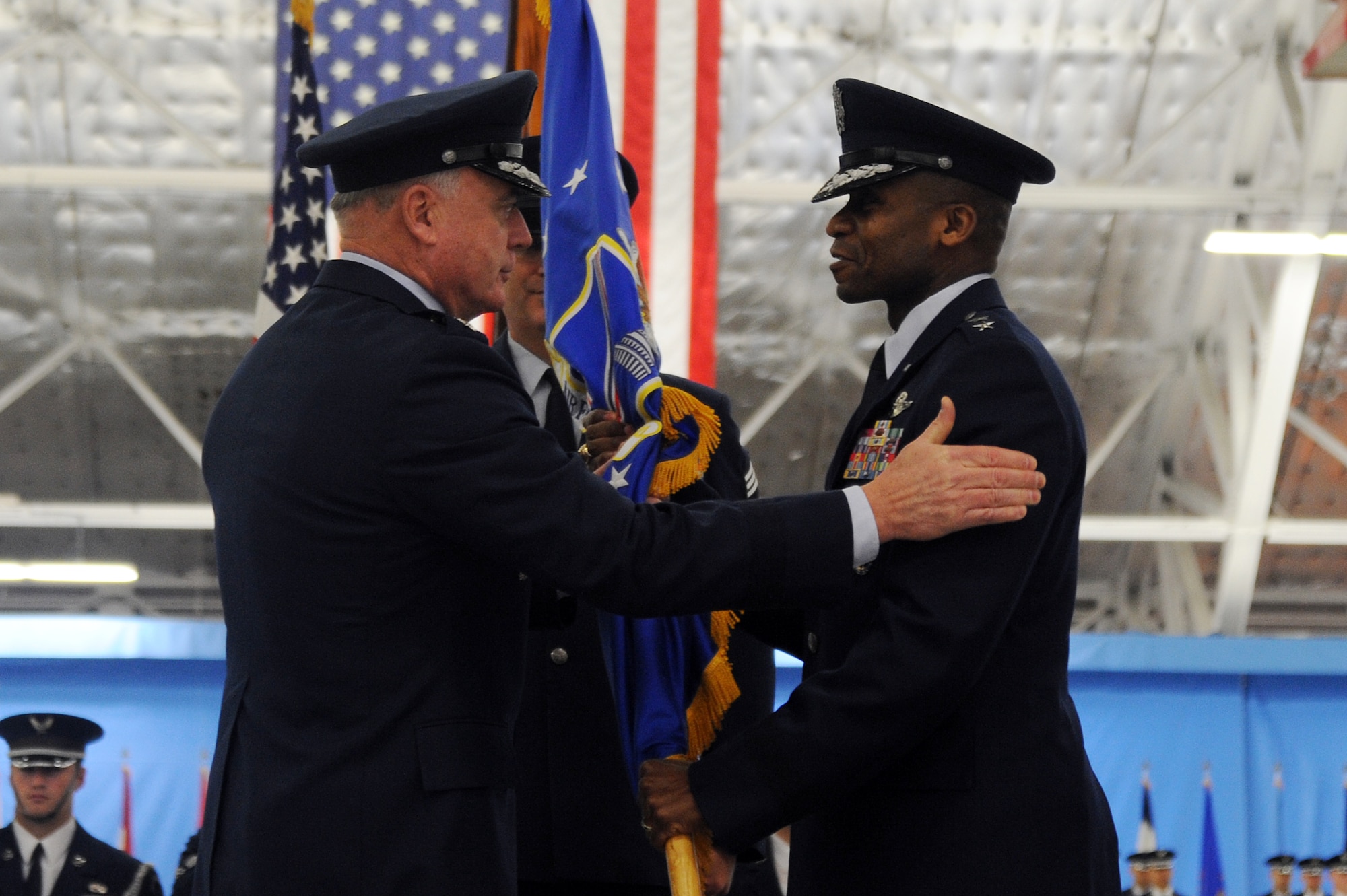 Air Force Vice Chief of Staff Gen. Carrol H. "Howie" Chandler congratulates Maj. Gen. Darren W. McDew, the new Air Force District of Washington commander, after passing him the unit guidon during a change of command ceremony at Andrews Air Force Base, Md., on Dec. 9, 2010.  General McDew's prior assignment was at the Pentagon, where he was the vice director of Strategic Plans and Policy on the Joint Staff. (U.S. Air Force photo/Senior Airman Melissa V. Brownstein)
