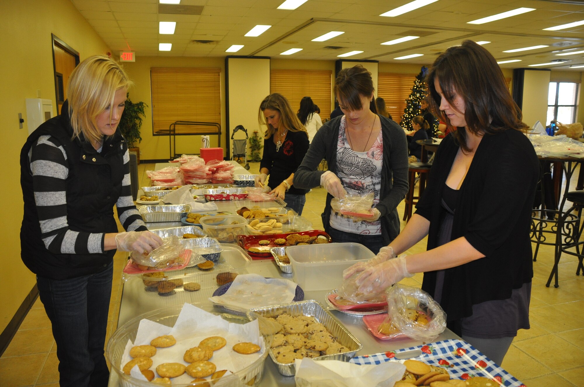 LAUGHLIN AIR FORCE BASE, Texas - - Volunteers for the Officer’s Spouses Club Cookie Caper pick out cookies to be packaged for single active duty members of Laughlin.  Volunteers put together 642 packages to be distributed around base housing and dorm rooms. (U.S. Air Force photo by 2nd Lt. Angela Martin) 