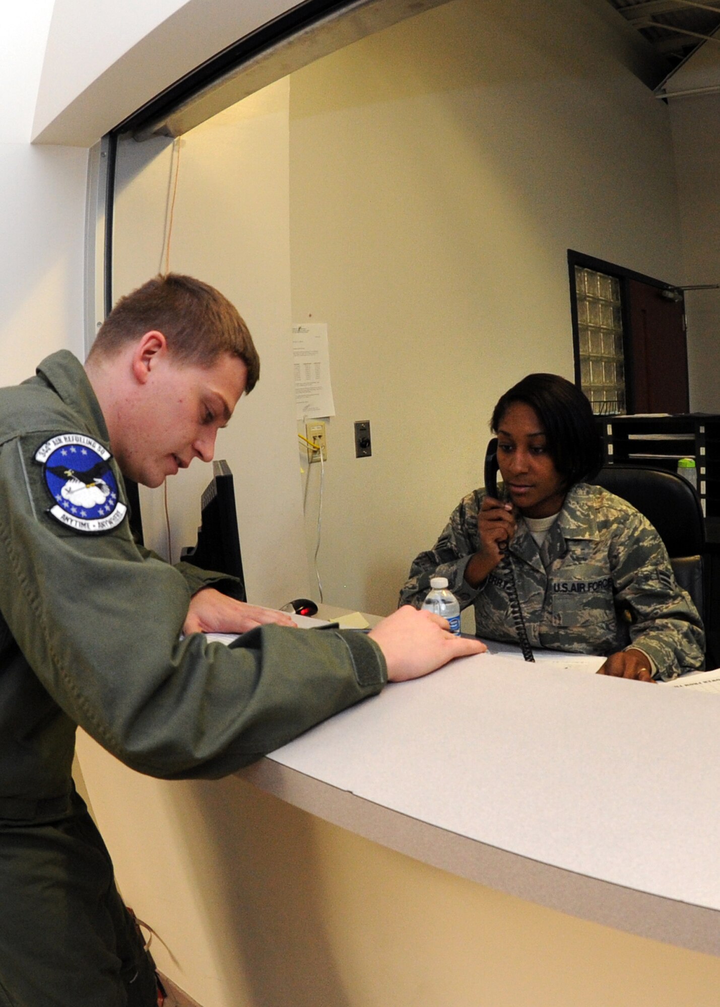 Airman 1st Class Tanisha Sedberry, 22nd Operations Support Squadron aviation resource management apprentice, assists Airman 1st Class Chris Reed, 344th Air Refueling Squadron boom operator, submit required paperwork to update his training records at the Combined Squadron Operations Center inside Building 1186, Dec. 7, 2010, McConnell Air Force Base, Kan. The Aviation Resource Management flight validates that aircrew members have met daily aircraft safety and physical requirements before authorizing them to proceed to their assigned aircraft. (U.S. Air Force photo/Airman 1st Class Andrea Salazar)