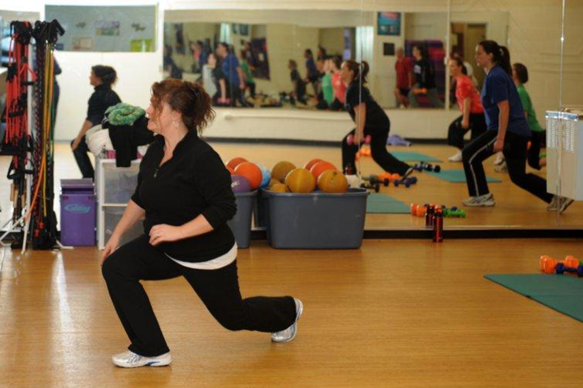 SEYMOUR JOHNSON AIR FORCE BASE, N.C. – Sharon Grieve, BellaMorphosis director, demonstrates a proper lunge as she instructs a fitness class the BellaMorphesis gym, Dec. 6, 2010. Mrs. Grieve is well known in the gym for her outgoing personality, knowledge in fitness and her ability to bring people out of their shell.  She is married to Tech Sgt. Christopher Grieve of the 4th Civil Engineer Squadron and has been a fitness instructor at the gym since their arrival here in 2003. (U.S. Air Force photo/Senior Airman Marissa Tucker)