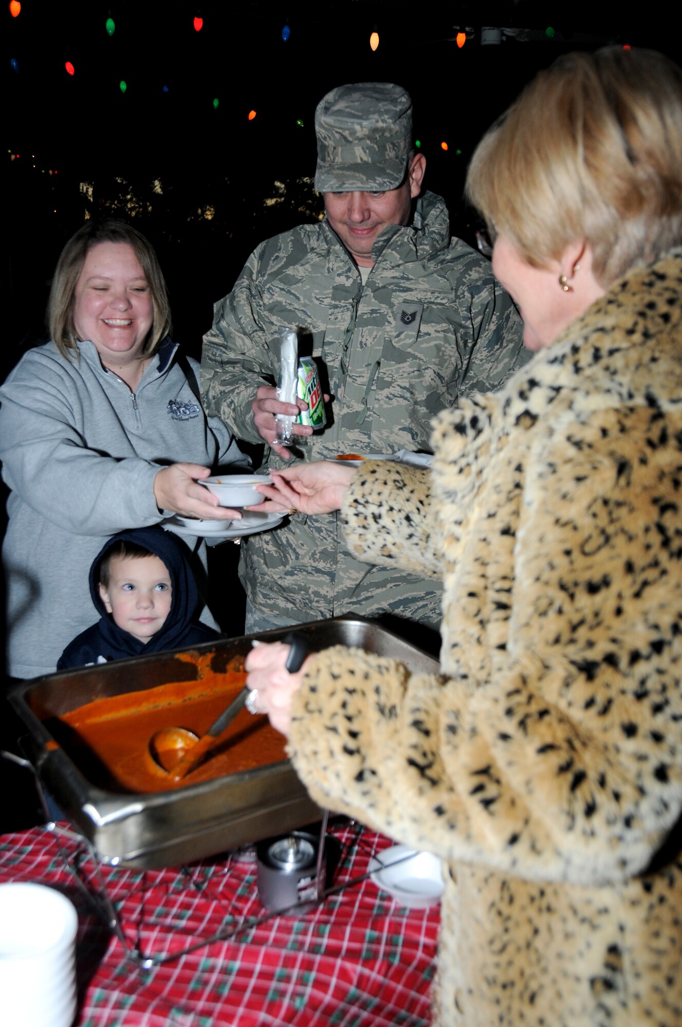 Tech. Sgt. Ivan and Michelle Smith, 81st Training Support Squadron, and their 4-year-old son, Ian, are served chili by Carmen Steed, 81st Force Support Squadron, at Holiday in the Park, Dec. 1 at marina park.  (U.S. Air Force photo by Kemberly Groue)