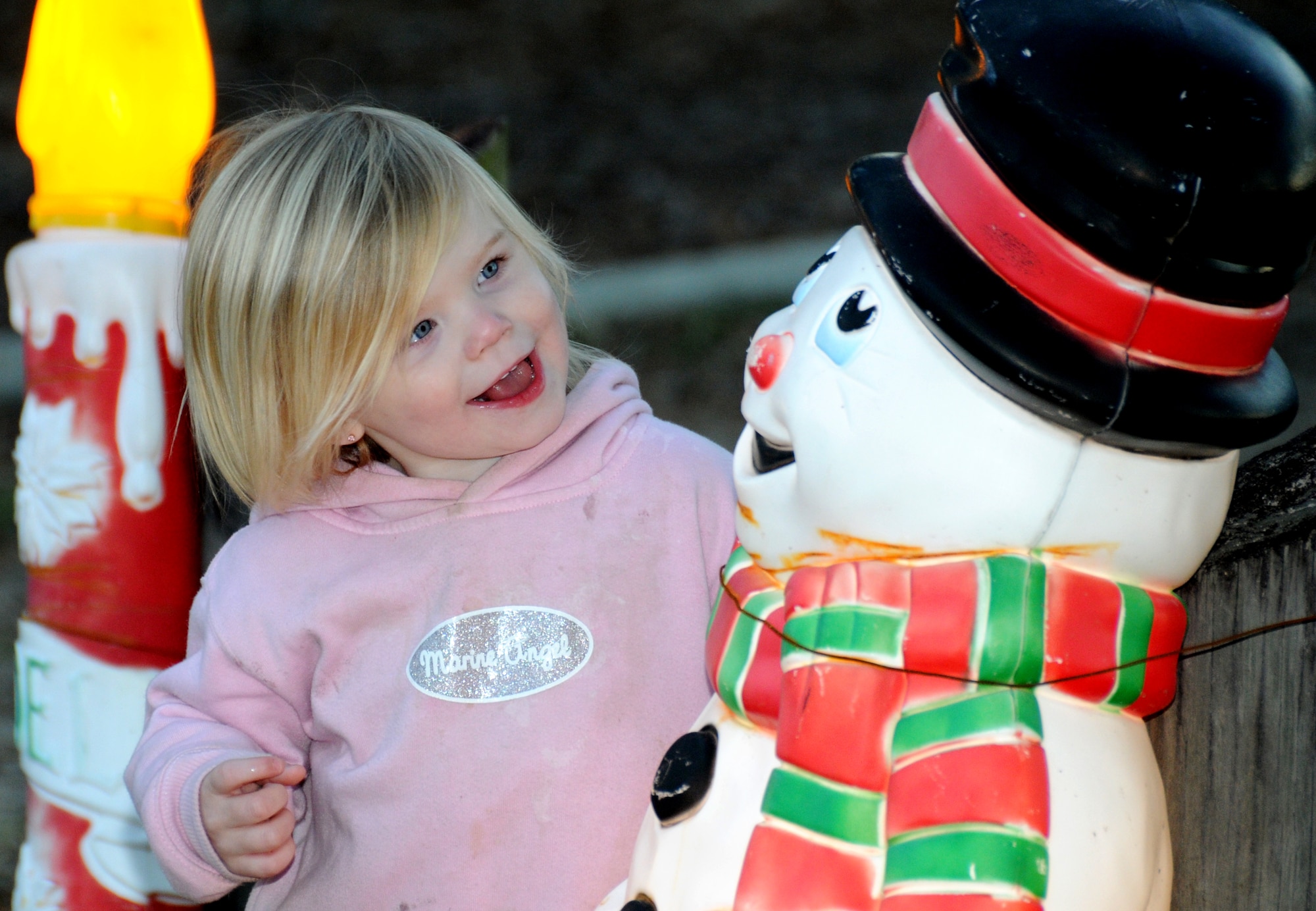 Alexia Wilson, 2, daughter of Cpl. Timothy and Amy Wilson, Keesler Marine Corps Detachment, is having a chat with Frosty the Snowman and finding they have much in common — same smile and same red, cute as a button nose.  (U.S. Air Force photo by Kemberly Groue)