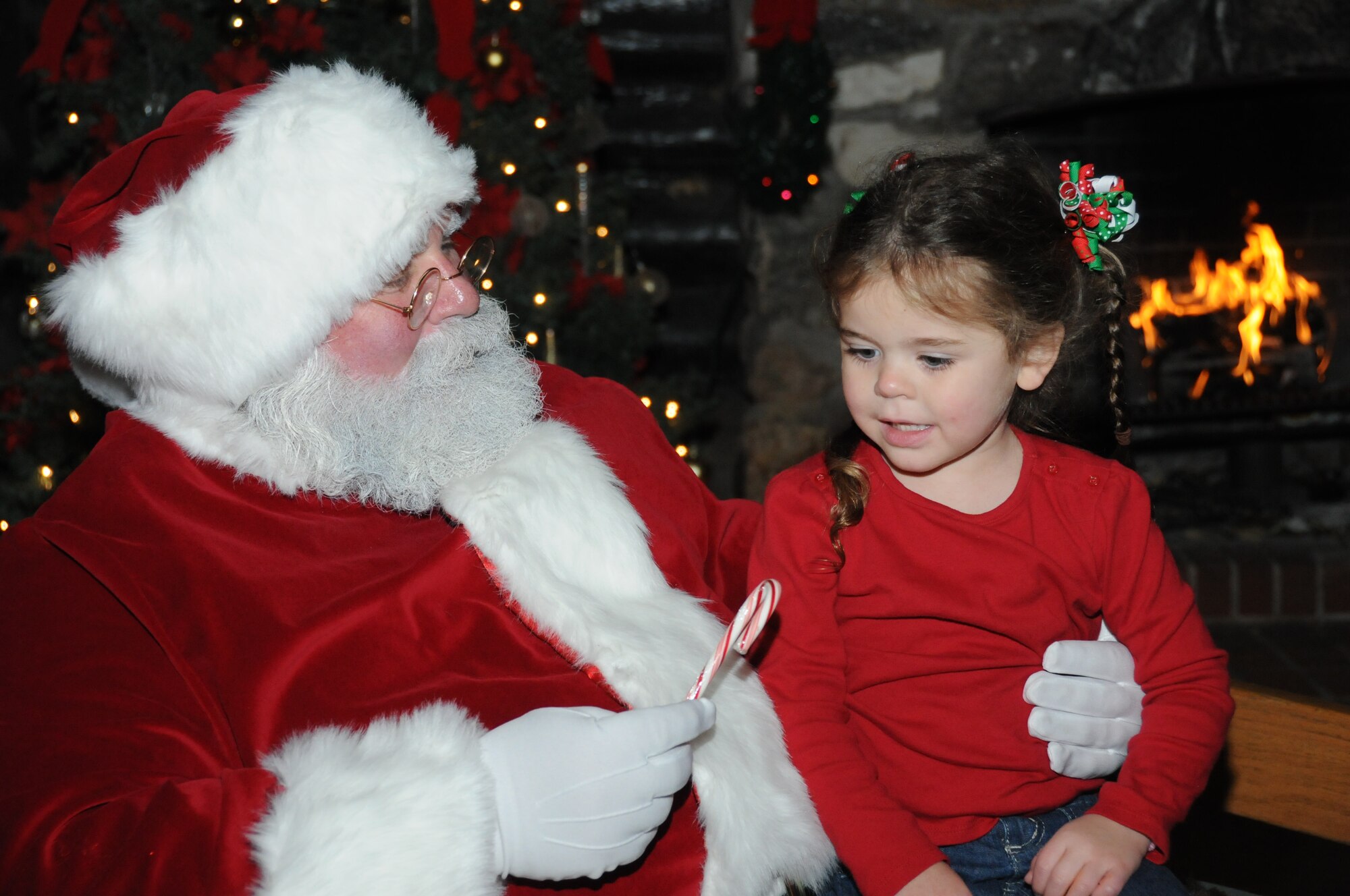 After making her gift requests known, Jenna Douberly, 4, daughter of Tech. Sgt. Dustin
and Shannon Douberly, 81st Training Support Squadron, receives a candy cane from
Santa Claus to foreshadow the gifts that will arrive on Christmas morning.  (U.S. Air Force photo by Kemberly Groue)