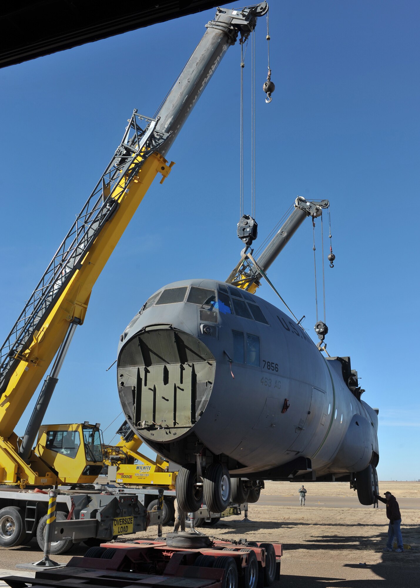 Workers from Wilhite Crane Services from Clovis, N.M., hoist a fuselage trainer that will be housed at Cannon Air Force Base, Dec. 8. 27th Special Operations Wing Airmen soon will have the ability to train loading and unloading cargo using night vision devices and the fuselage.  (U.S. Air Force photo by Senior Airman James Bell)