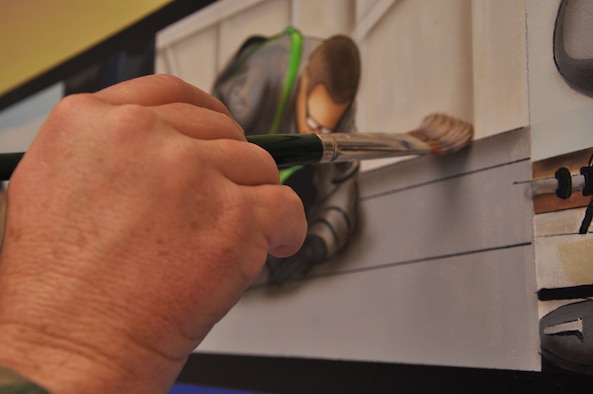 WRIGHT-PATTERSON AIR FORCE BASE, Ohio - Master Sgt. Roland Stinnette, 445th Maintenance Operations Flight, puts the finishing touches on his mural located in building 4012, 445th Maintenance Group.  The mural took more than three weeks to complete and represents the 445th Airlift Wing and all the different units working together as a cohesive unit. (U.S. Air Force Photo/Staff Sgt. Amanda Duncan)