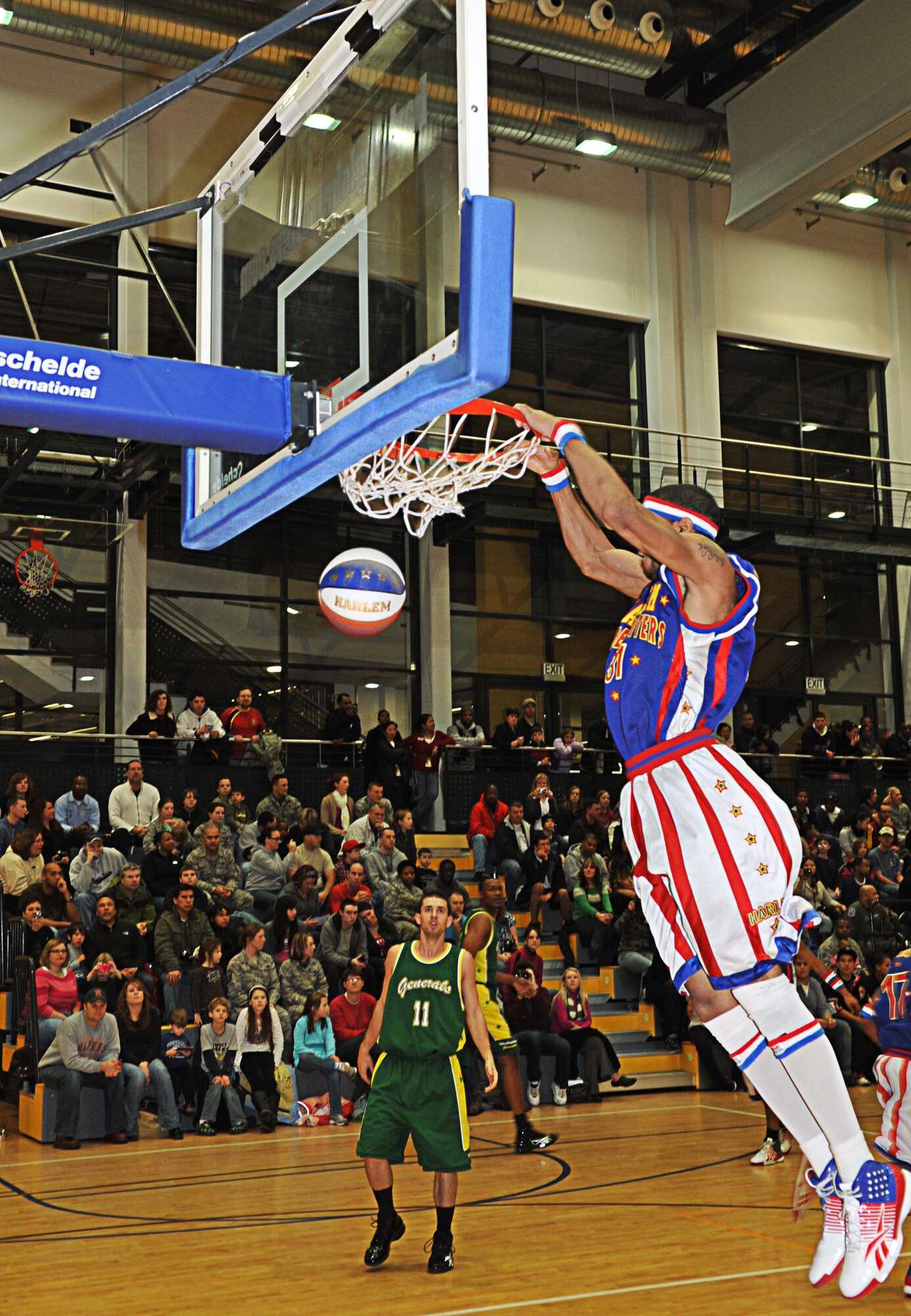 Hammer Harrison, Harlem Globetrotter, dunks during a game for military members and their families, Ramstein Air Base, Germany, Dec. 8, 2010. The Globetrotters are celebrating their 85th year entertaining audiences around the world. (U.S. Air Force photo by Airman 1st Class Desiree Esposito)