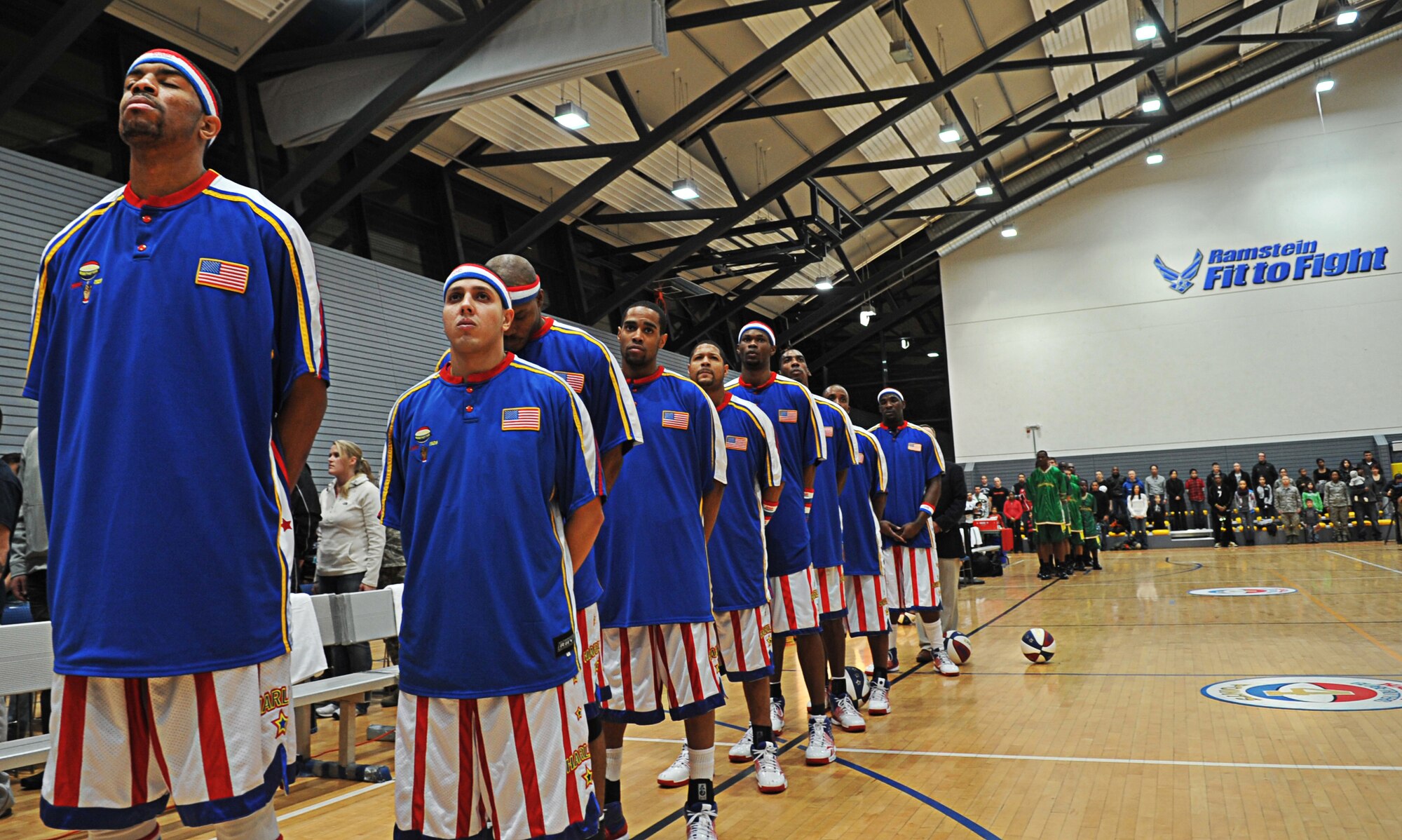 The Harlem Globetrotters pause for the National Anthem before performing for military members and their families during their ninth Military Holiday tour, Ramstein Air Base, Germany, Dec. 8, 2010. This tour was made possible by Navy Entertainment and Armed Forces Entertainment; this year's tour will feature 11 games on U.S. military bases in five countries: Germany, Italy, Greece, the Netherlands and the United Kingdom. The Globetrotters are celebrating their 85th year entertaining audiences around the world. (U.S. Air Force photo by Airman 1st Class Desiree Esposito)